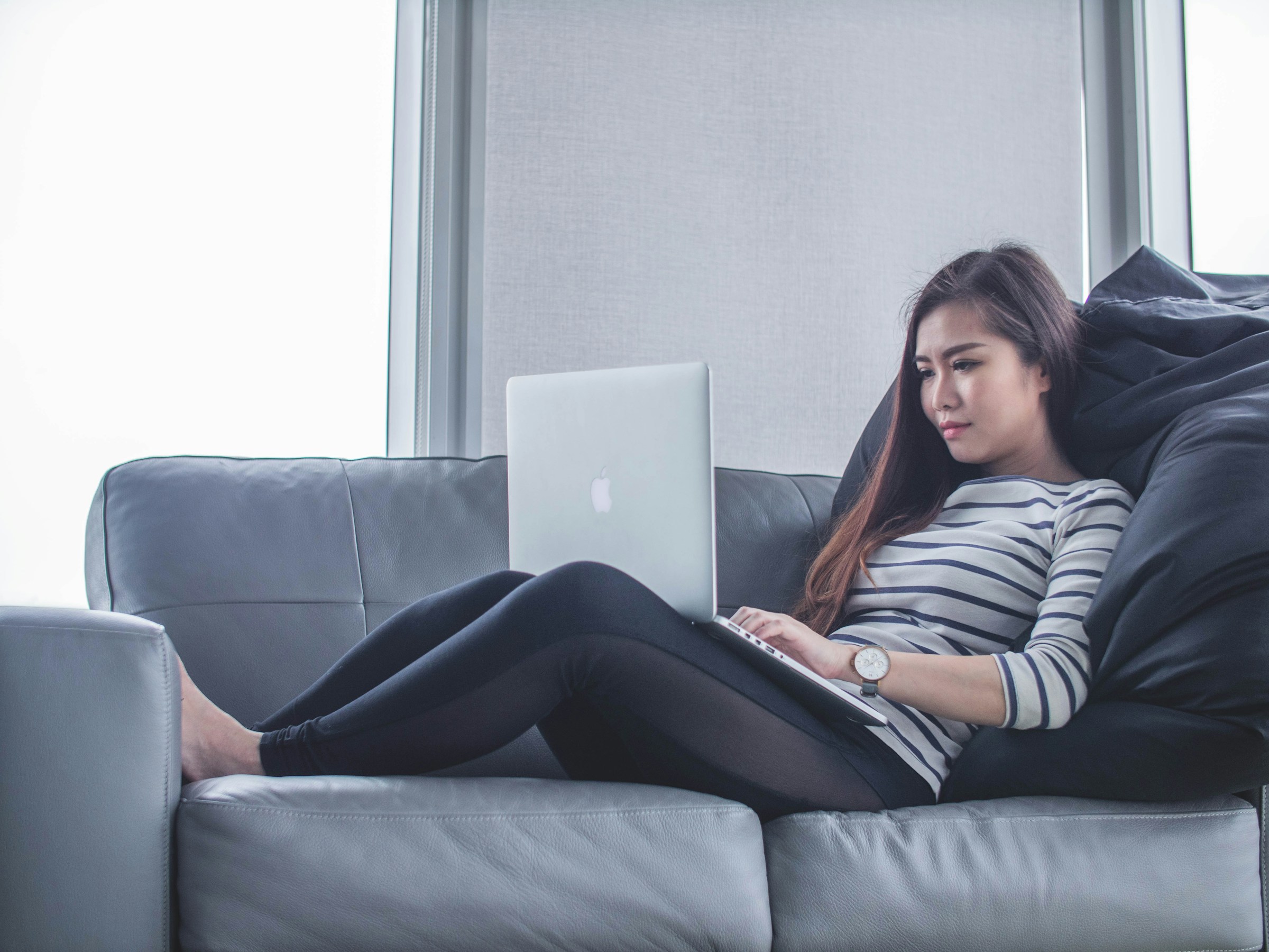 woman sitting on couch and working - Shopify Custom Sections