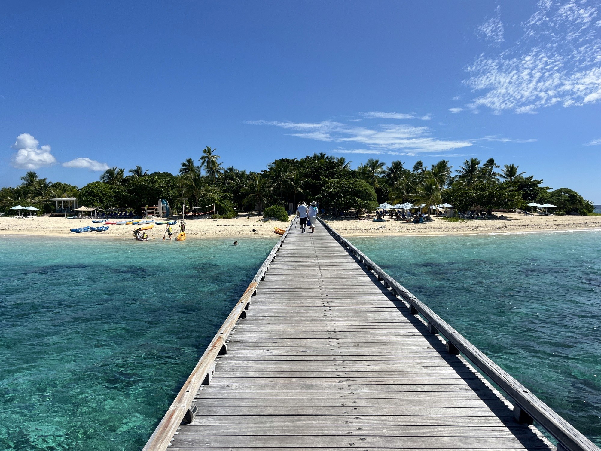 silhouette of people standing near body of water during sunset