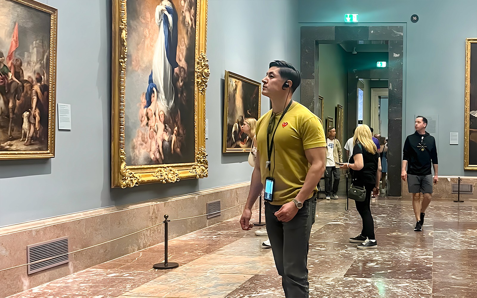 Visitors admiring paintings in Prado Museum, Madrid.