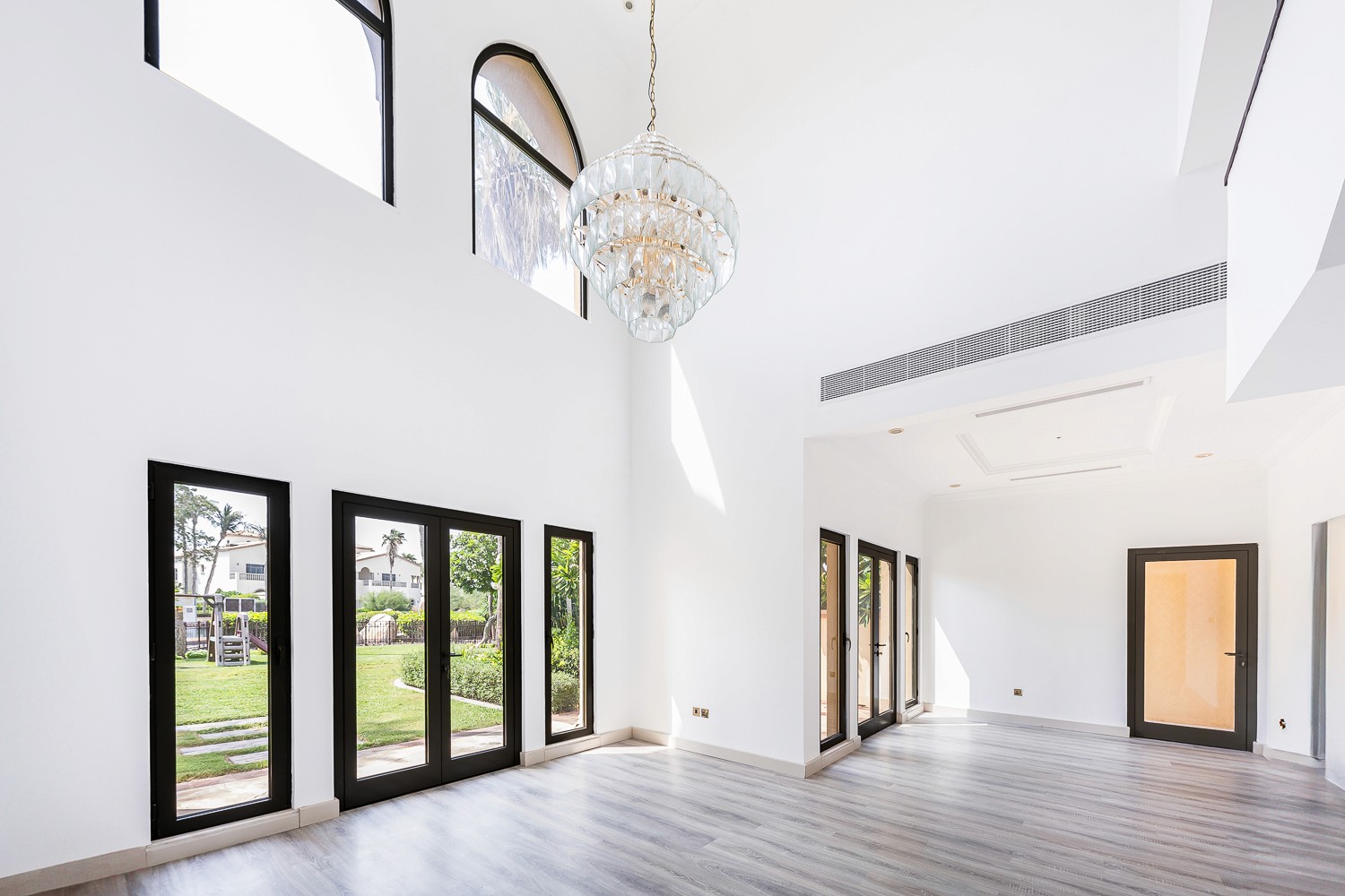 A spacious room with hardwood floors and large windows, showcasing the interior of Canal Cove Villas.