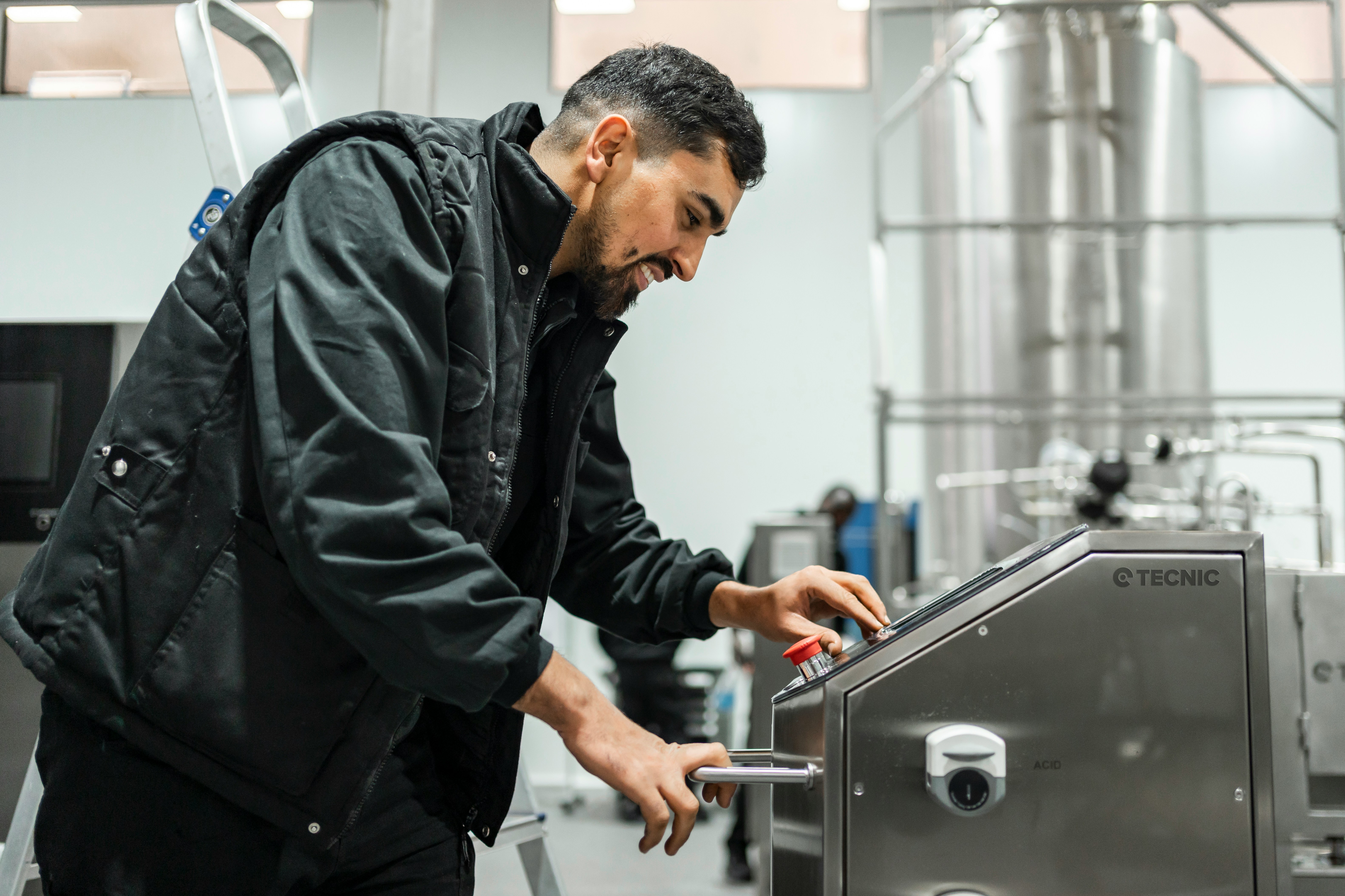 A man operates equipment in an industrial setting.