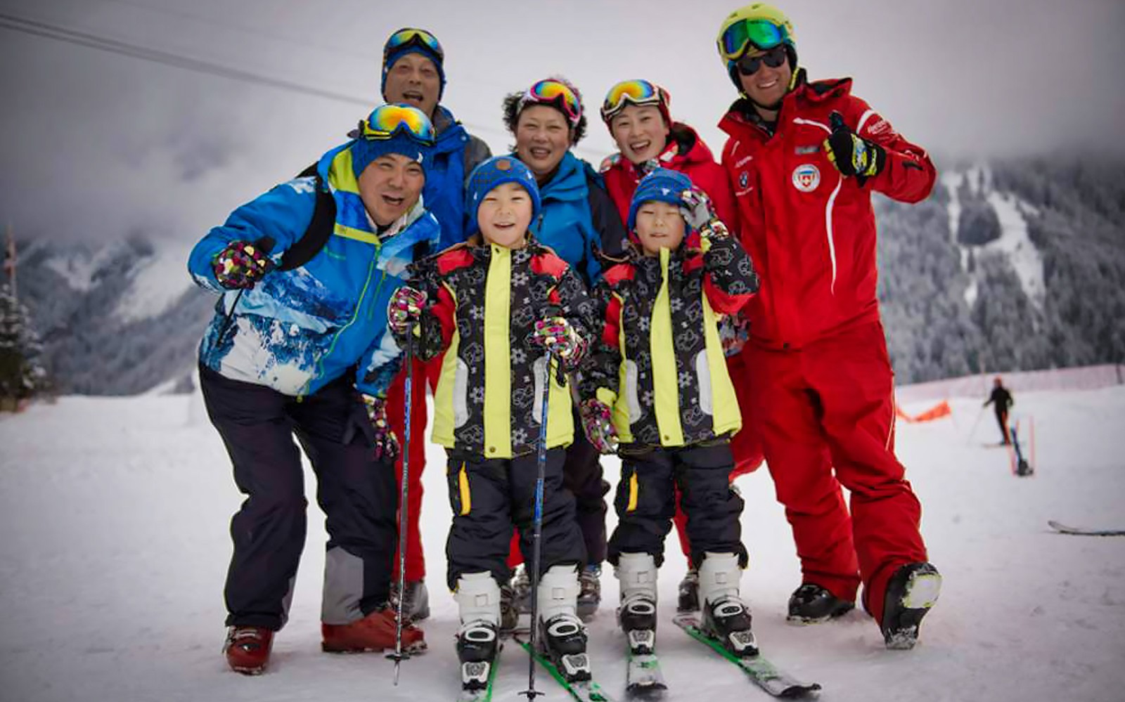 Grupp av skidåkare poserar på en snötäckt sluttning i Jungfrau-regionen, Schweiz.