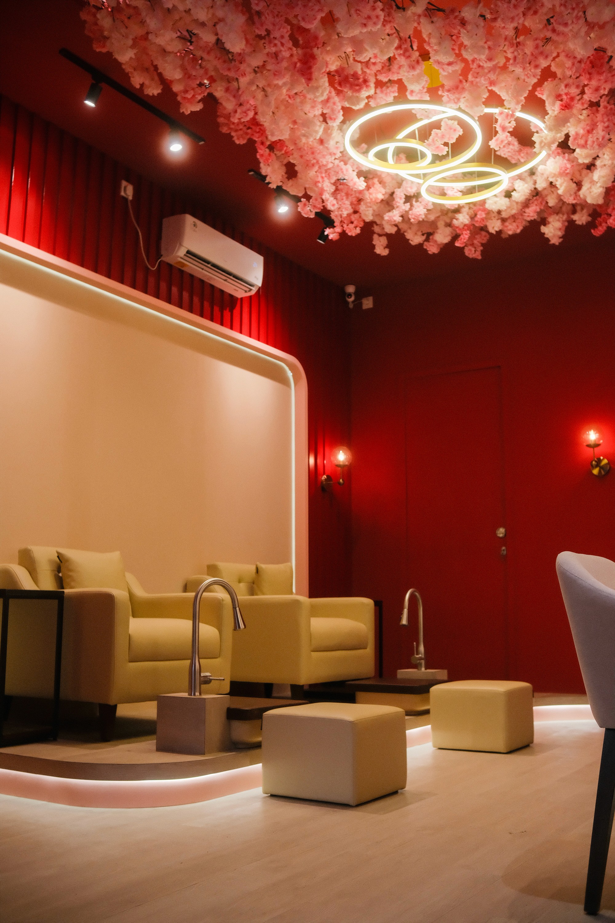 Cozy nail salon interior with flower decor, illuminated light, seating, and plumbing.