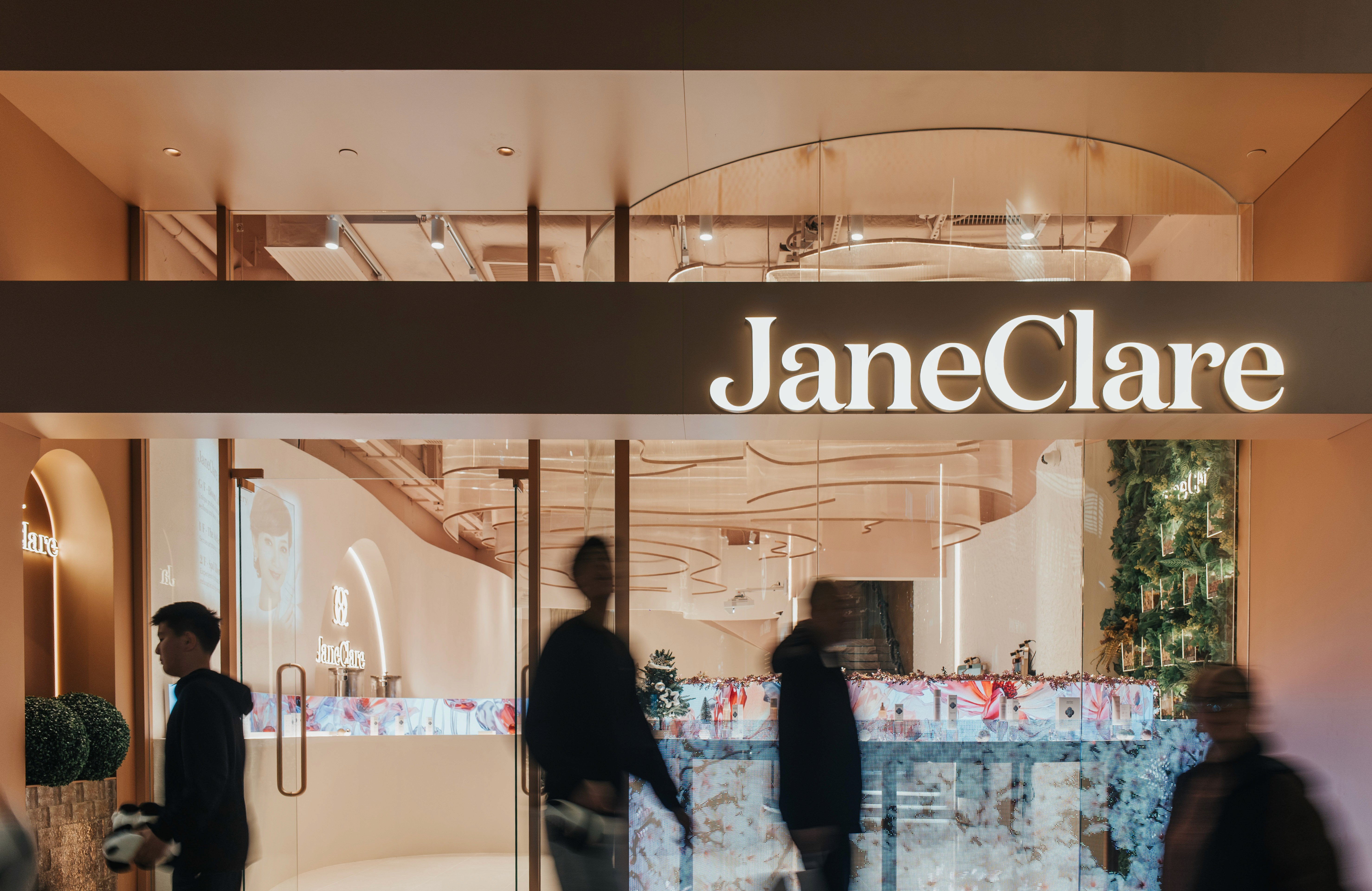 A street-level view of the modern storefront with customers blurred in motion near the entrance.