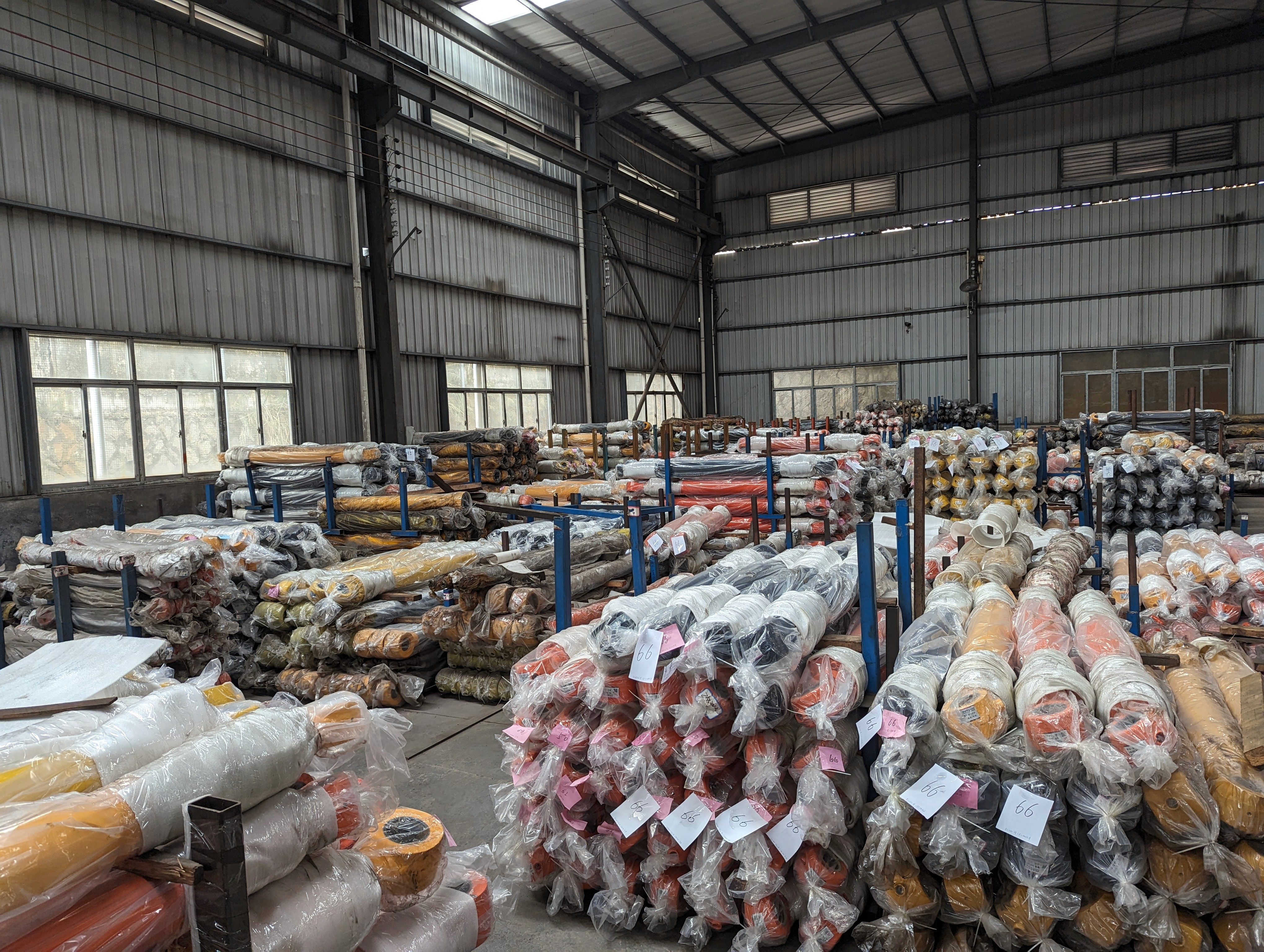 Aerial view of a hydroelectric dam spanning a turquoise river surrounded by dense forest and winding roads