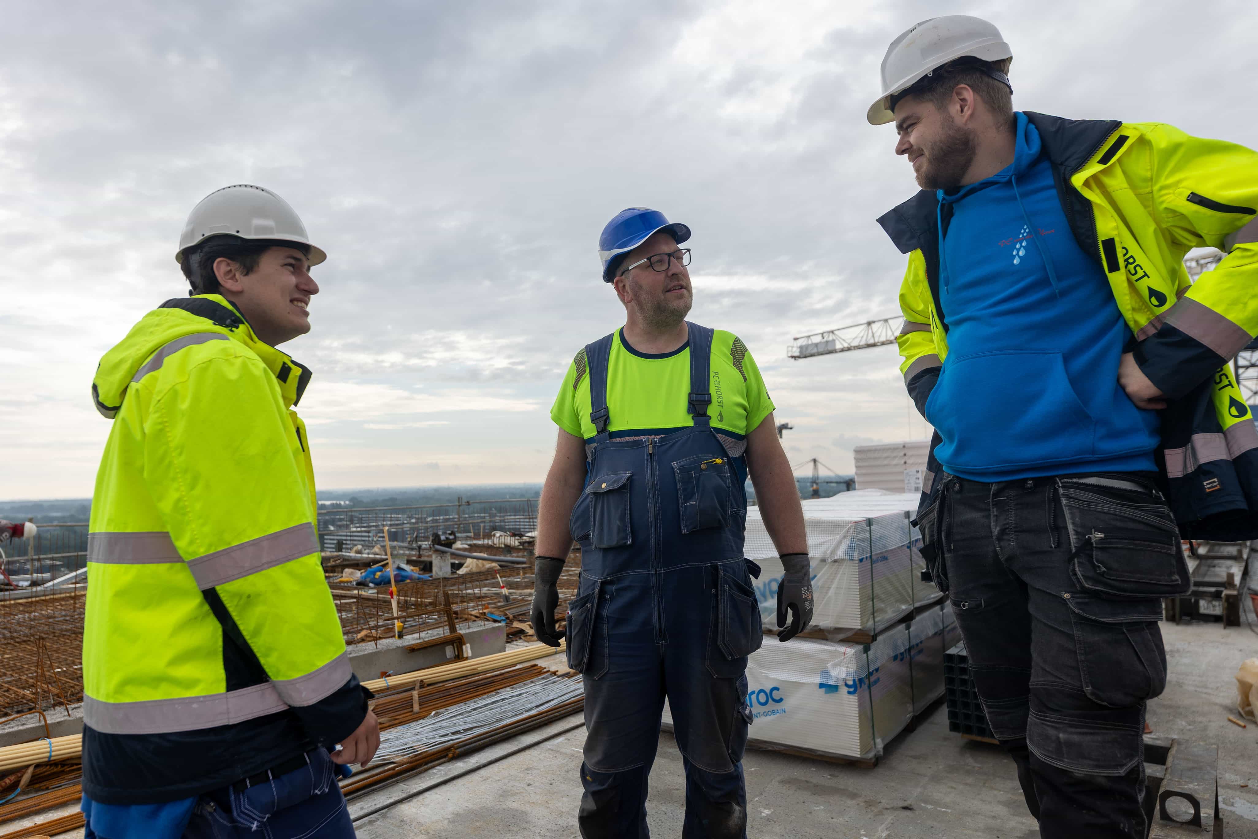 Werkoverleg tussen monteurs op bouwwerk hoogbouw PC van der Horst