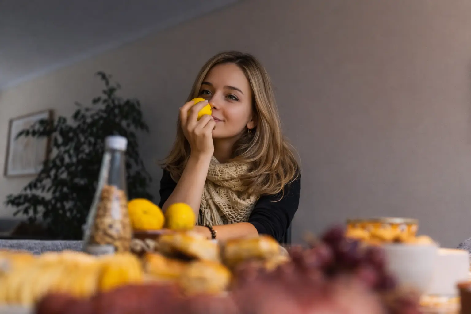 Smiling woman in her 40s laughing on a wooden swing at sunset, with mountain landscape in the background and cool cinematic color grading.