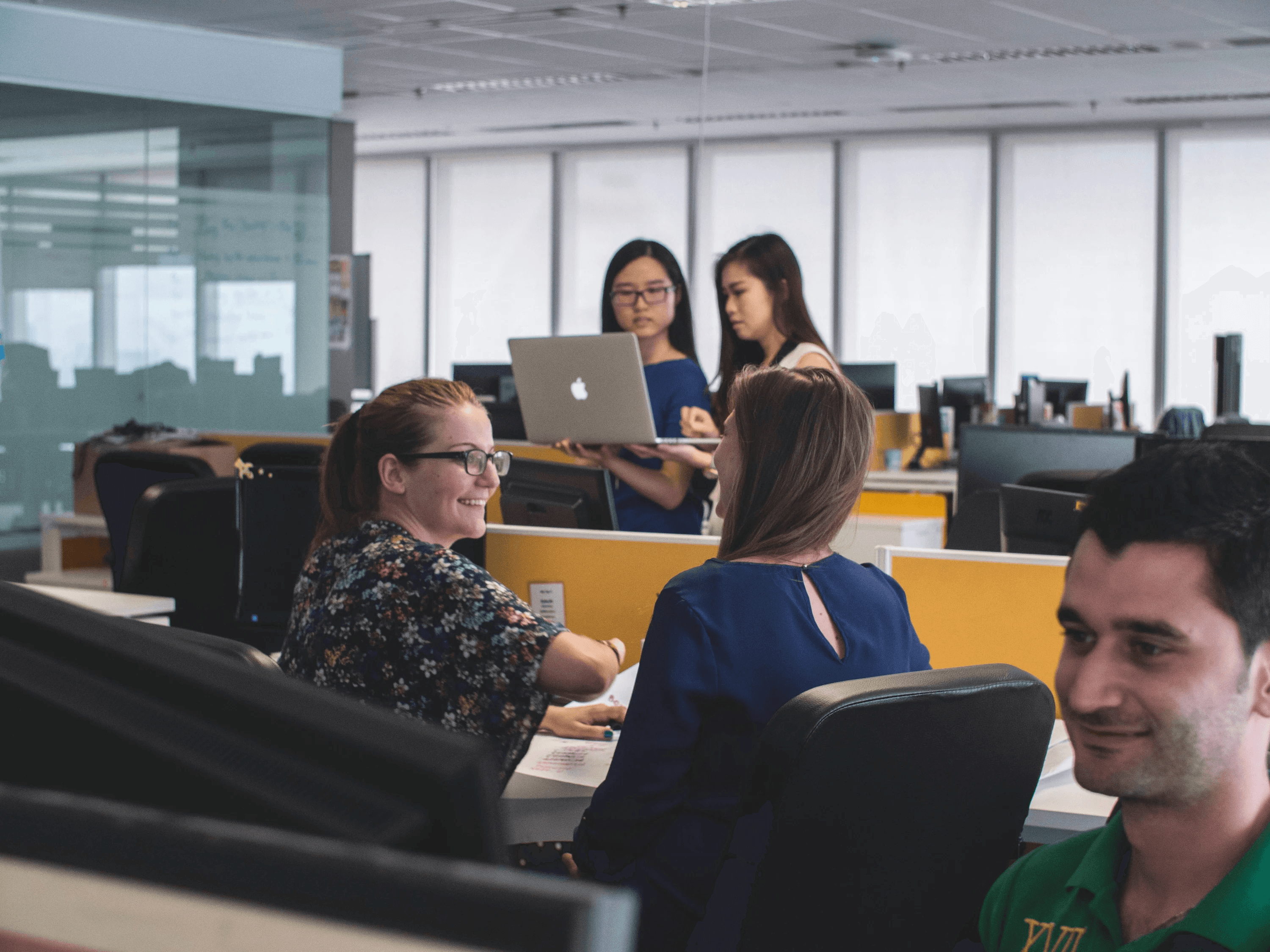 People working at computers in a conference room.