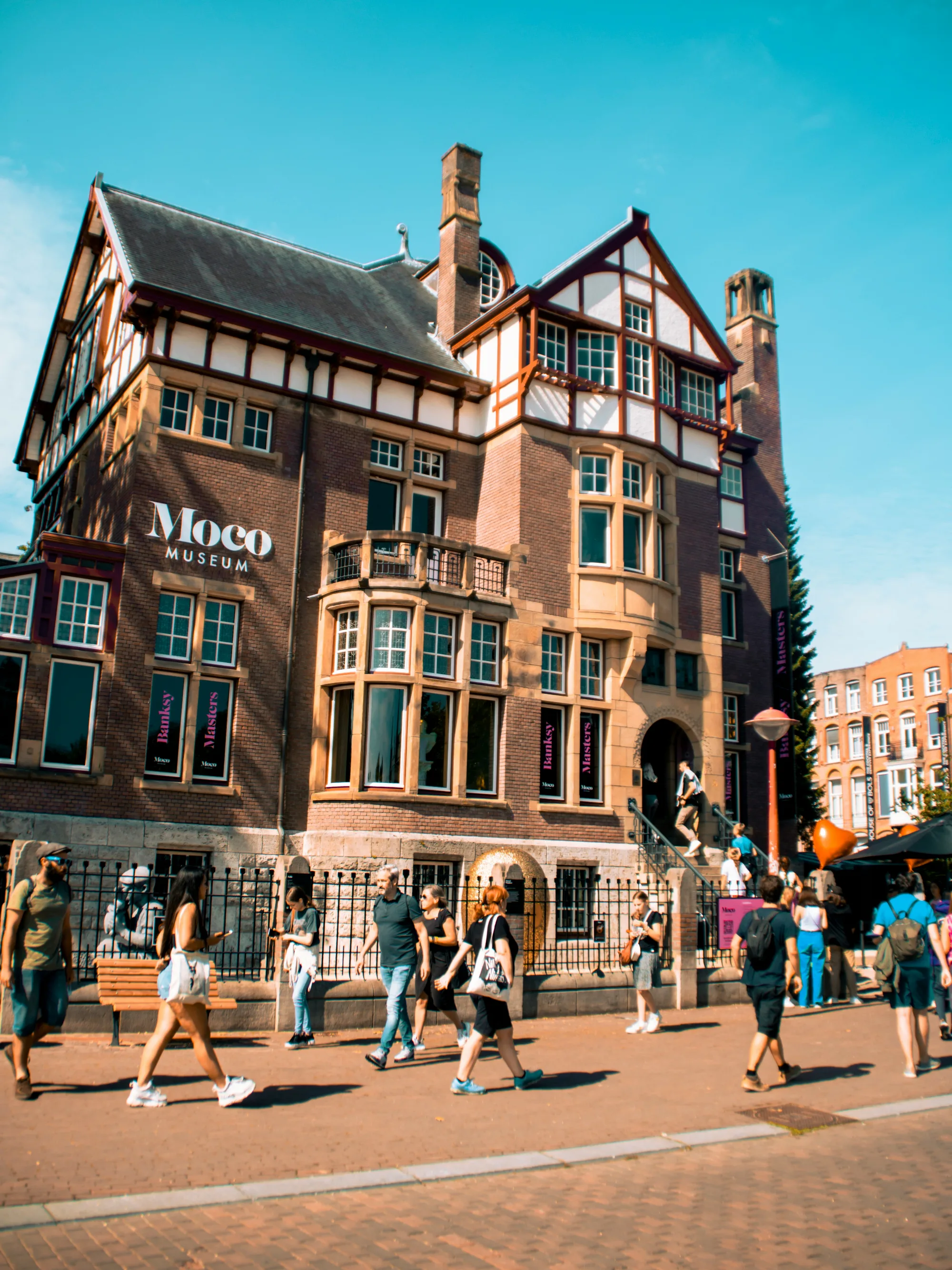Moco Museum in Amsterdam, a vibrant building with unique architecture attracting many visitors.