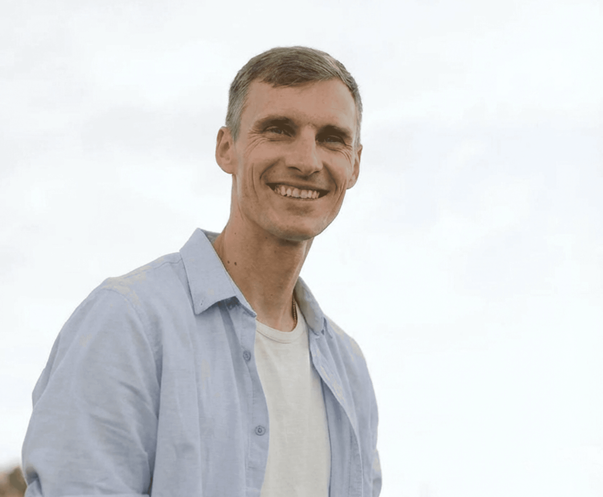 Woman smiling holding phone with provider on screen and a compounded semaglutide bottle next to her.