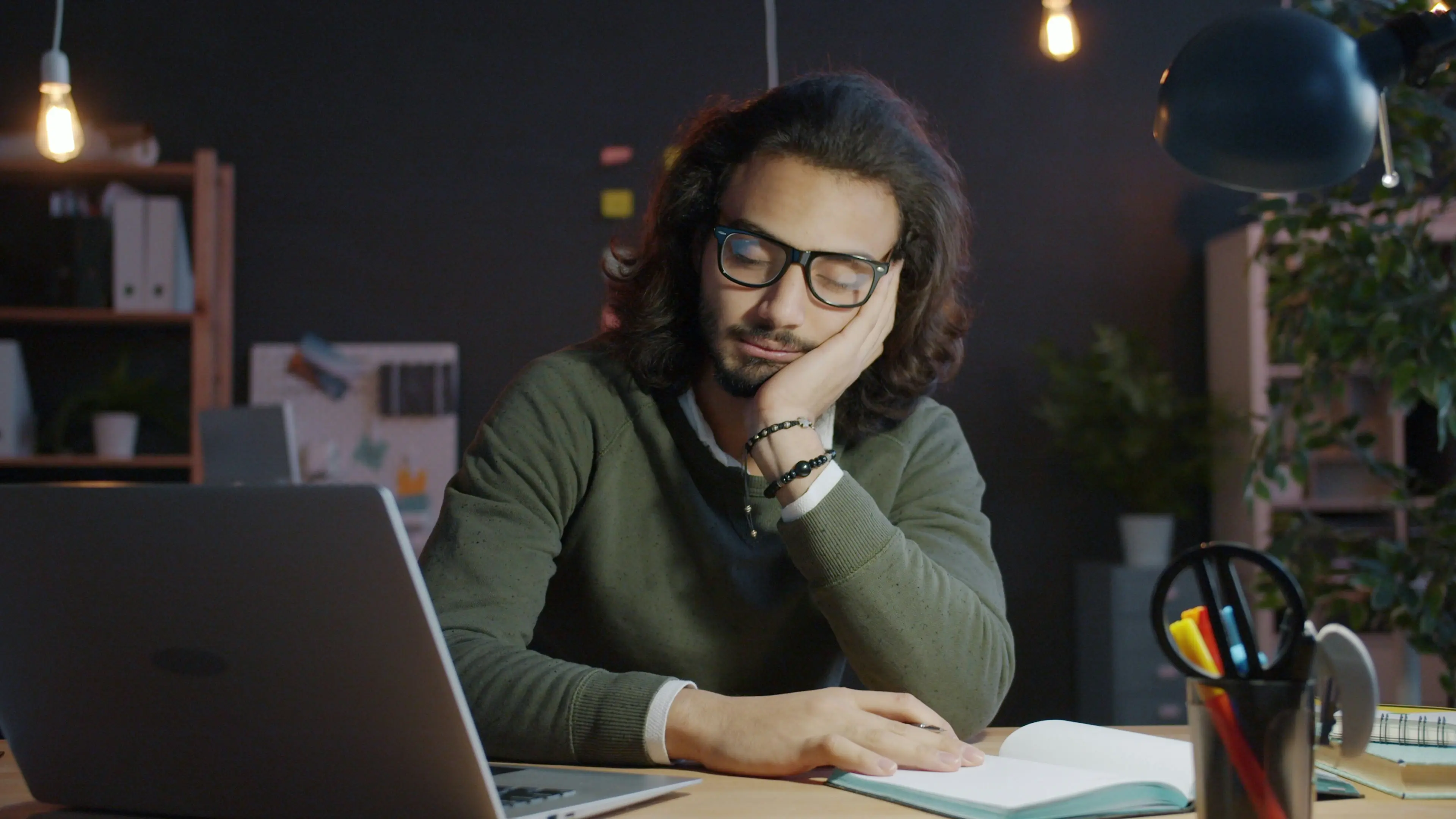 Professionnel fatigué travaillant tard devant un ordinateur dans un bureau sombre