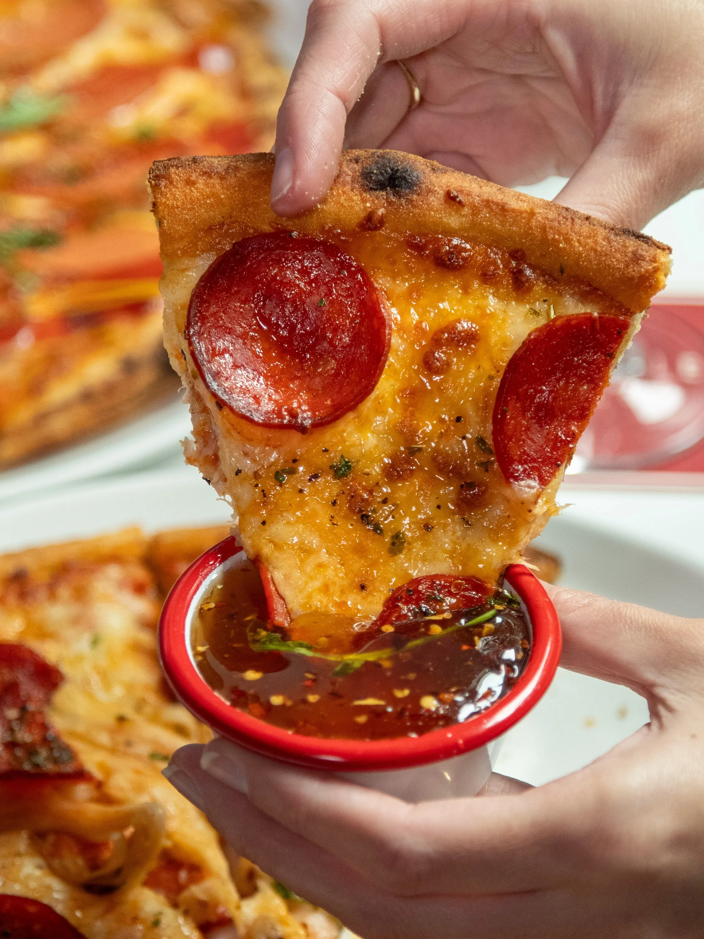 Pepperoni Pizza being dipped in hot maple