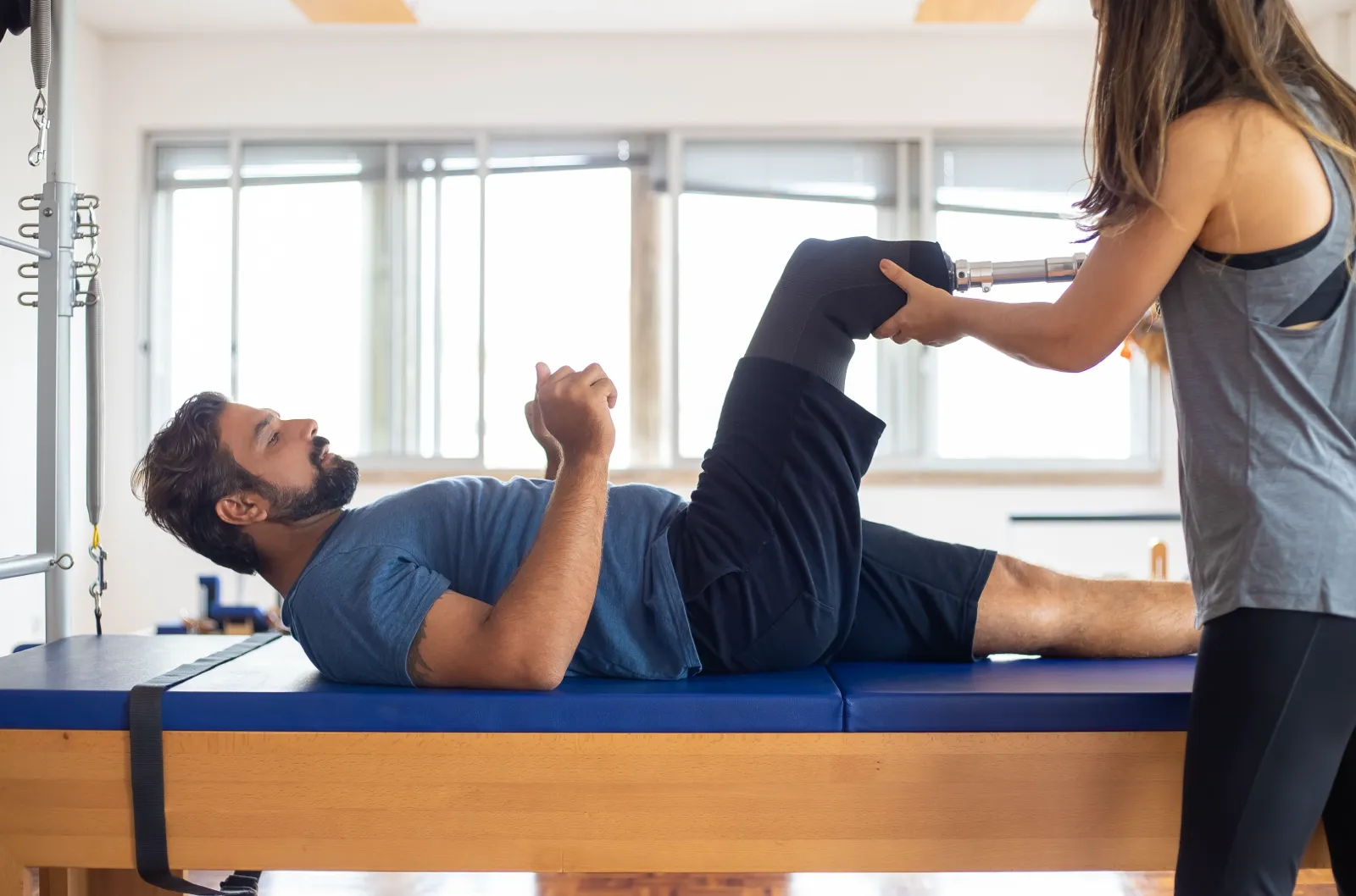 Physiotherapist stretching a client’s leg on a treatment table
