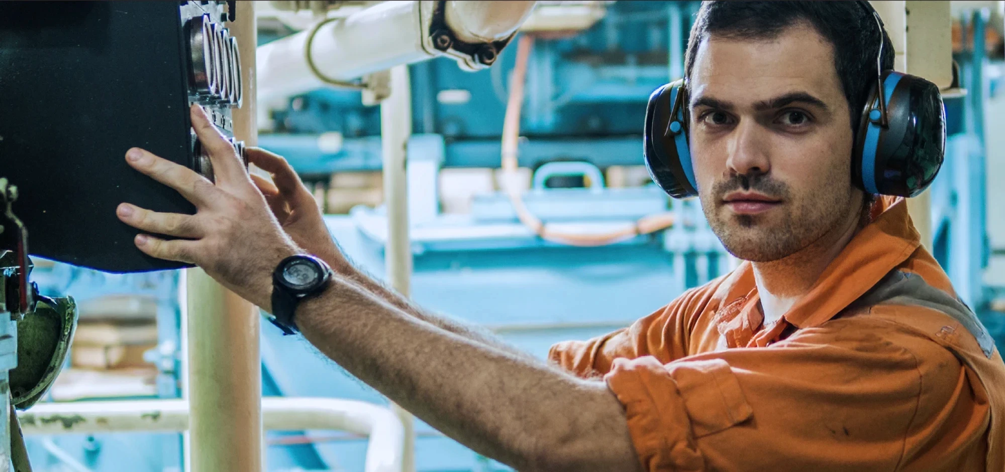 Man in industrial setting wearing ear protectors
