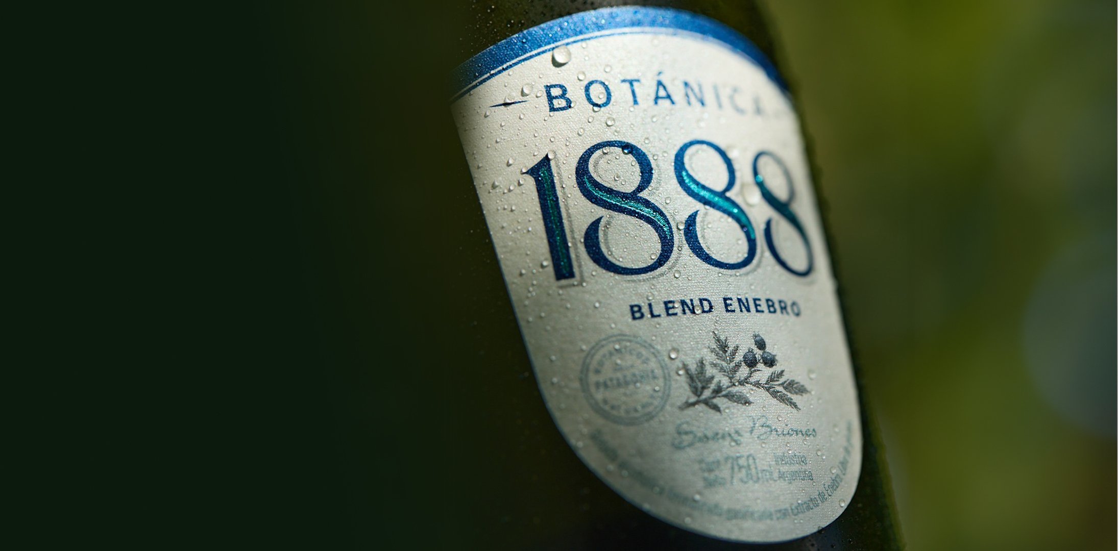 Close-up of a bottle label displaying the year "1888" and a logo against a blurred green background.