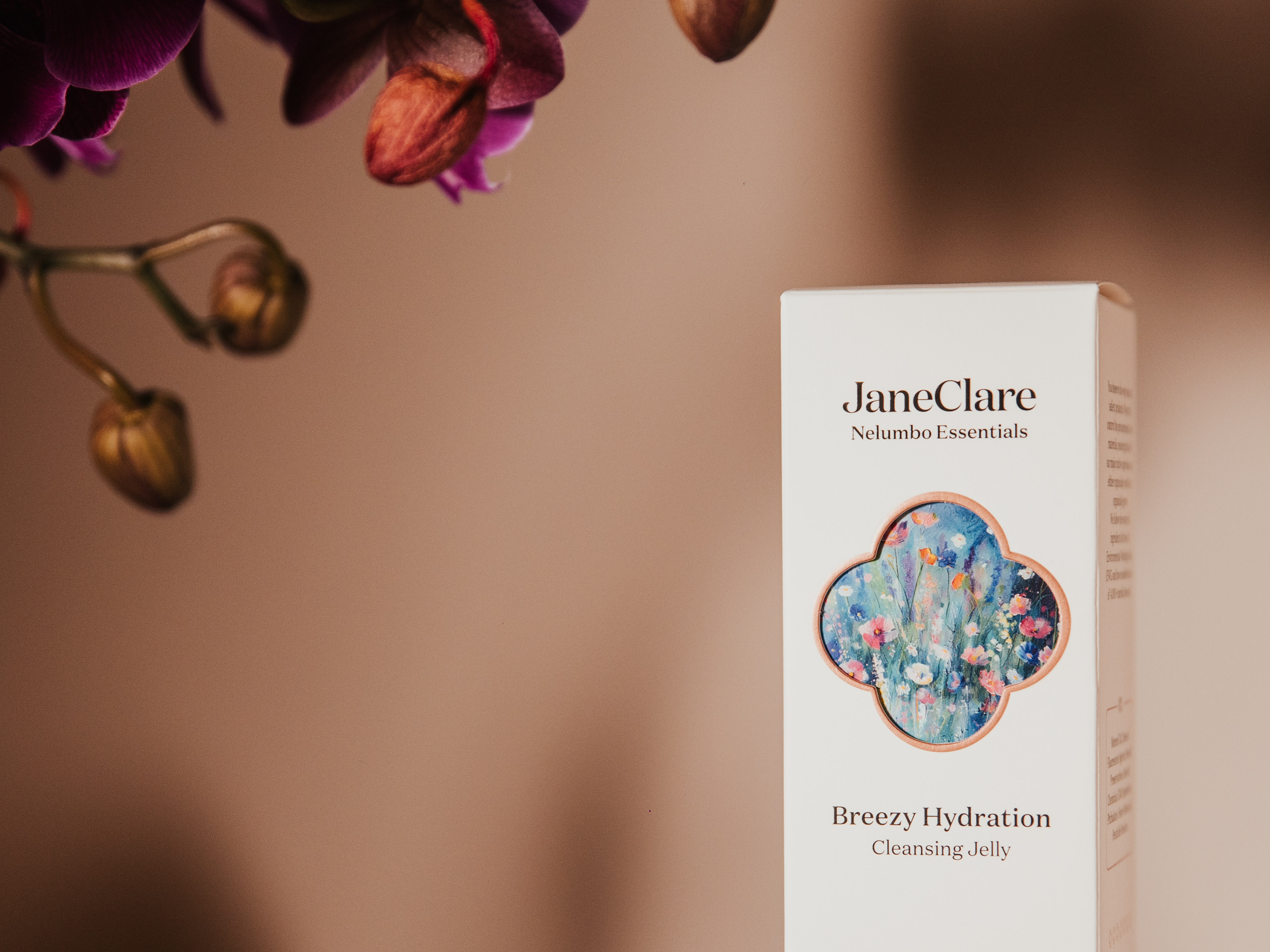 JaneClare Hydrating Wonder Serum and skincare product line in elegant packaging with floral background.