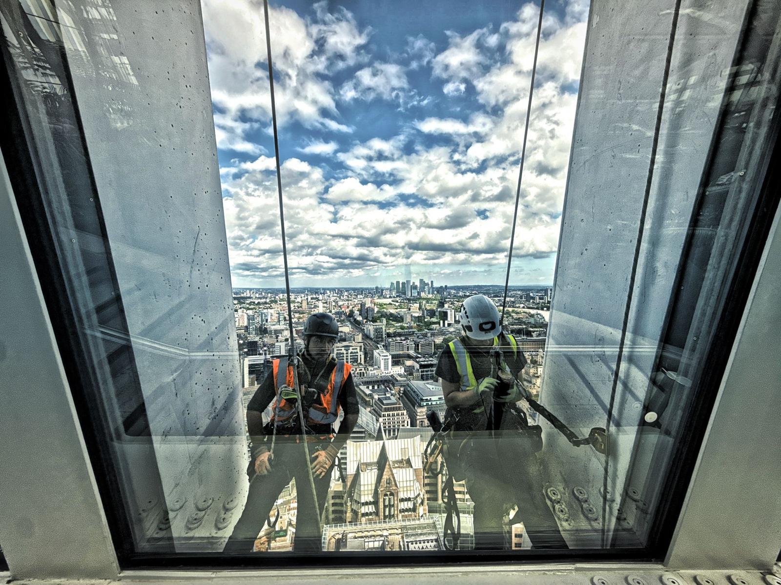 Rope-access technicians working outside high-level glazing