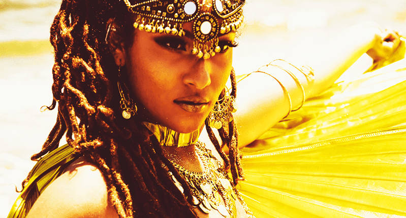 A golden photo of a woman wearing some tribal clothes and jewelry.