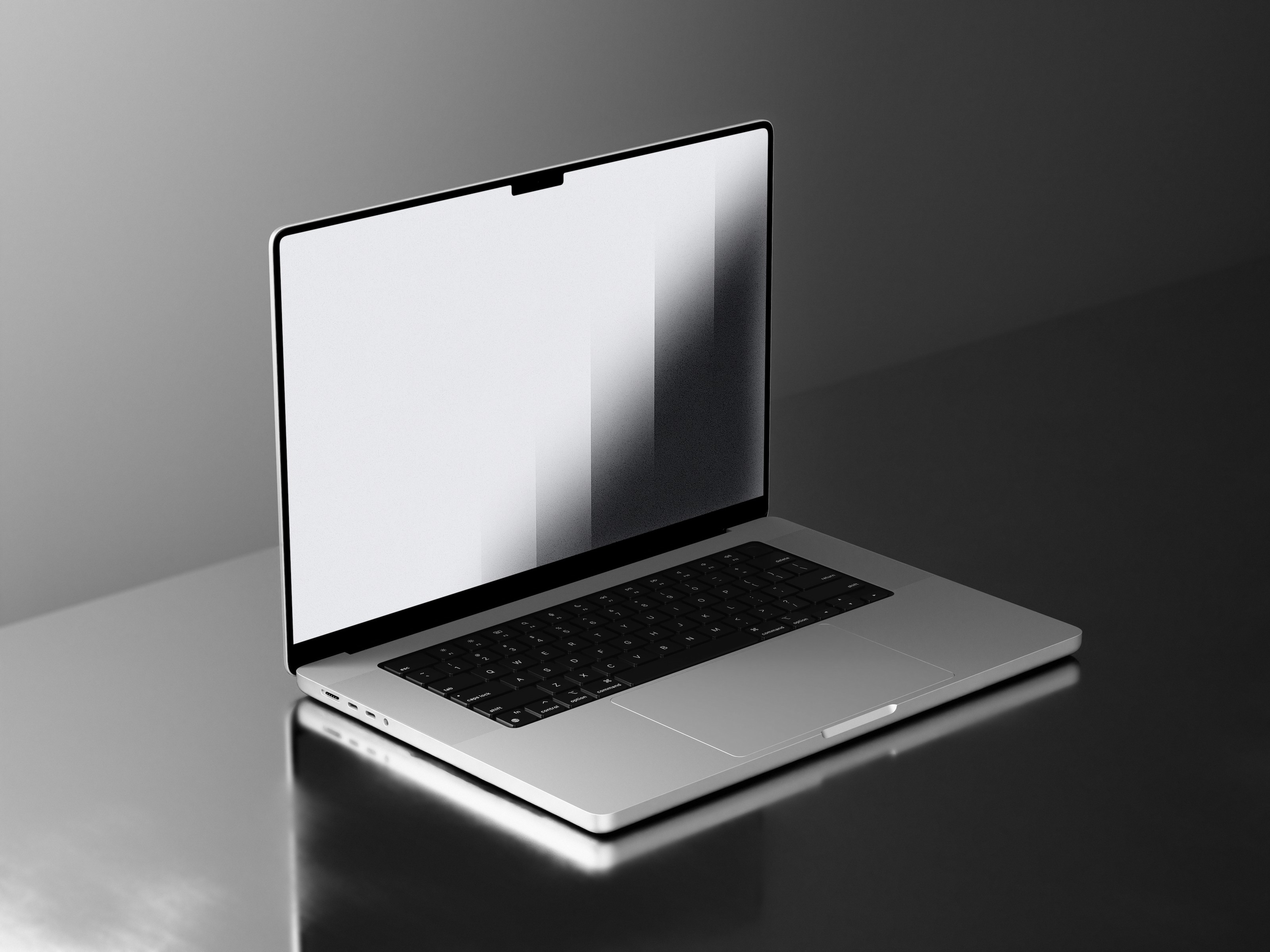 A sleek, modern laptop with a backlit keyboard and slim bezels sits open on a reflective, dark surface under soft lighting.