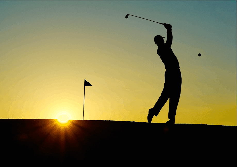 A silhouette of a man chipping a ball towards the green with the sun behind him.