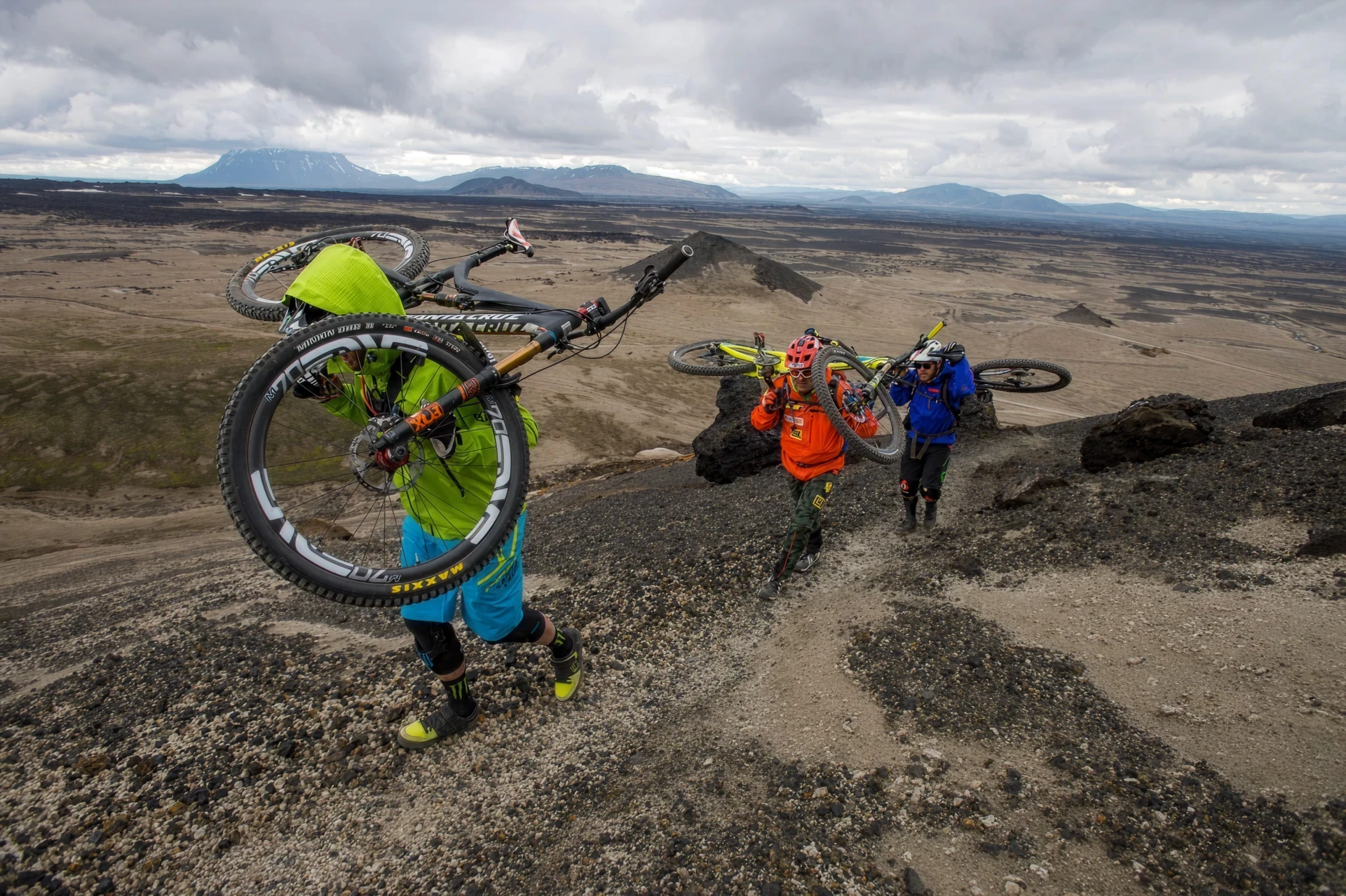 Riders carring MTB over mountain
