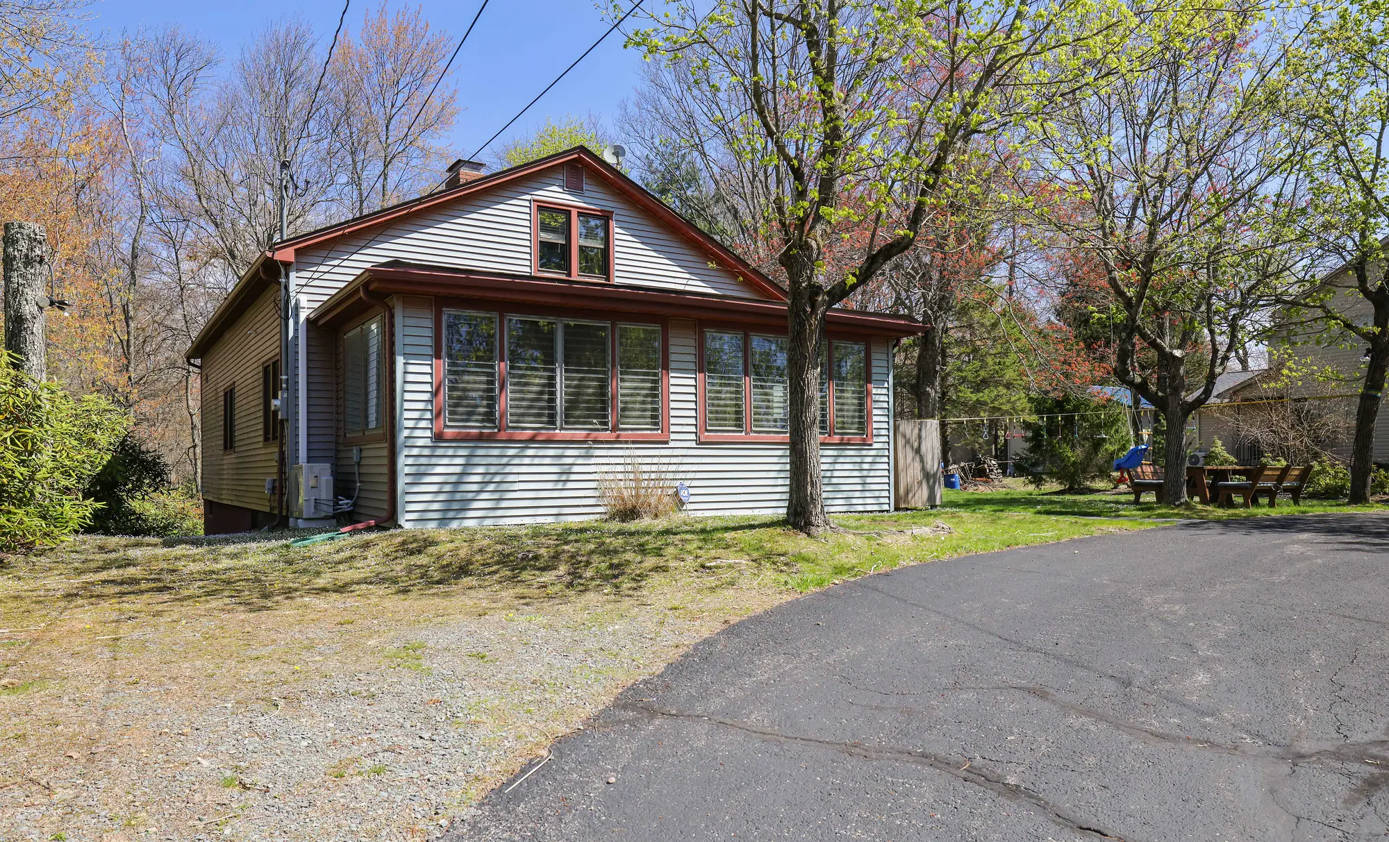 Gray cottage with enclosed sunroom and paved driveway at DeerPath Crossing, Lake Harmony, PA