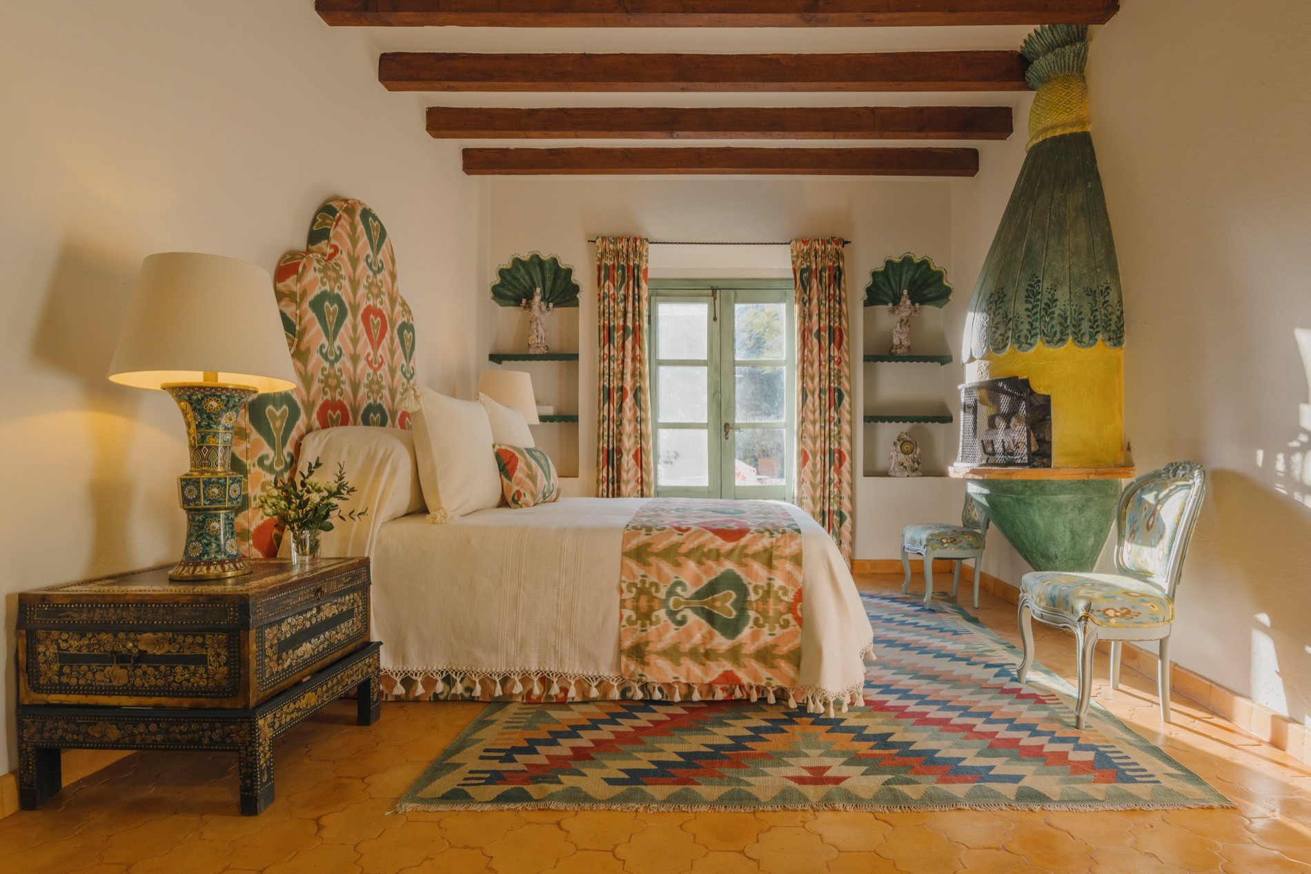 La Residencia guest bedroom with colorful ikat textiles and balcony doors