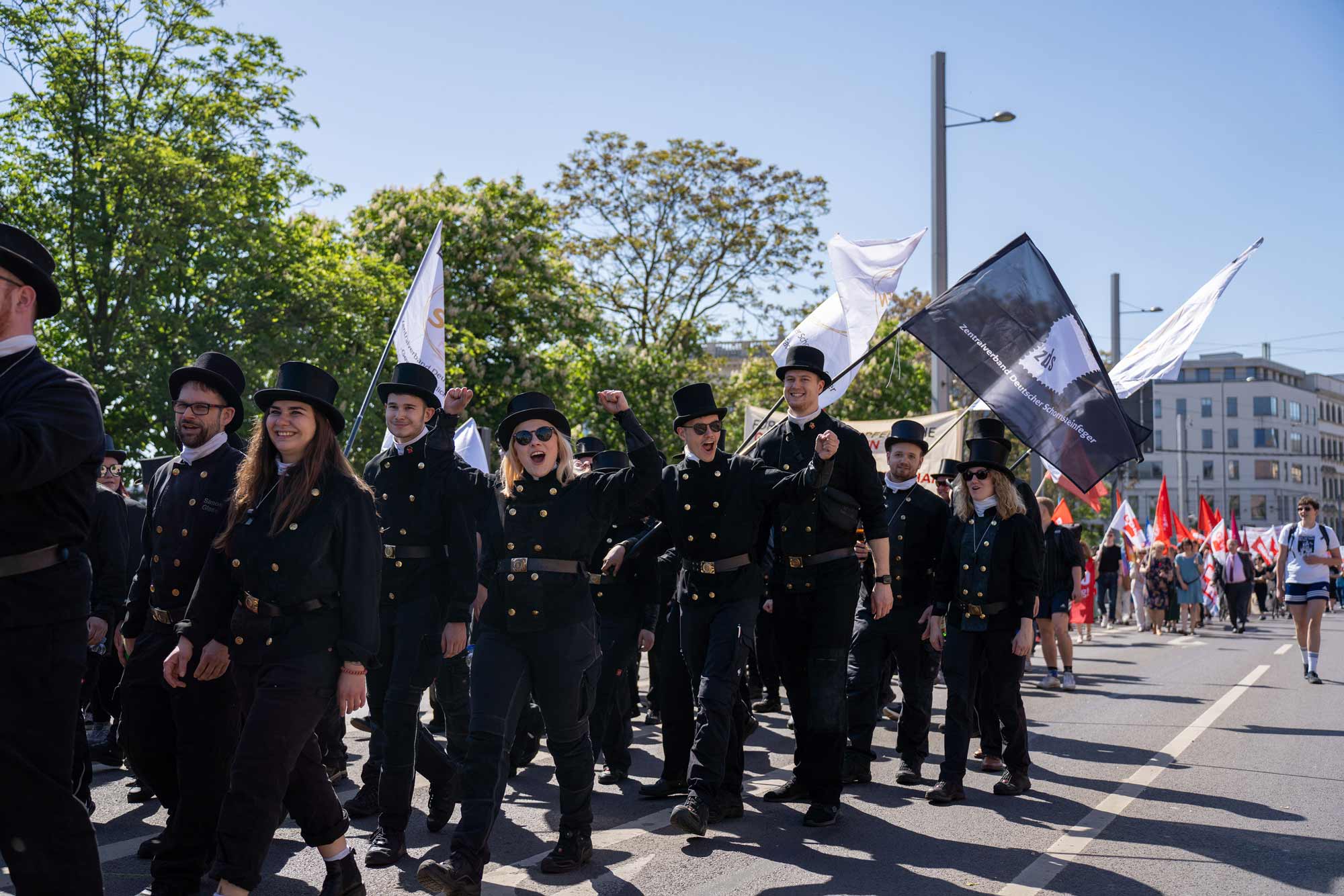 Chimney sweeps march with flags; a dynamic scene for strategic film production, storytelling, and social media campaigns.