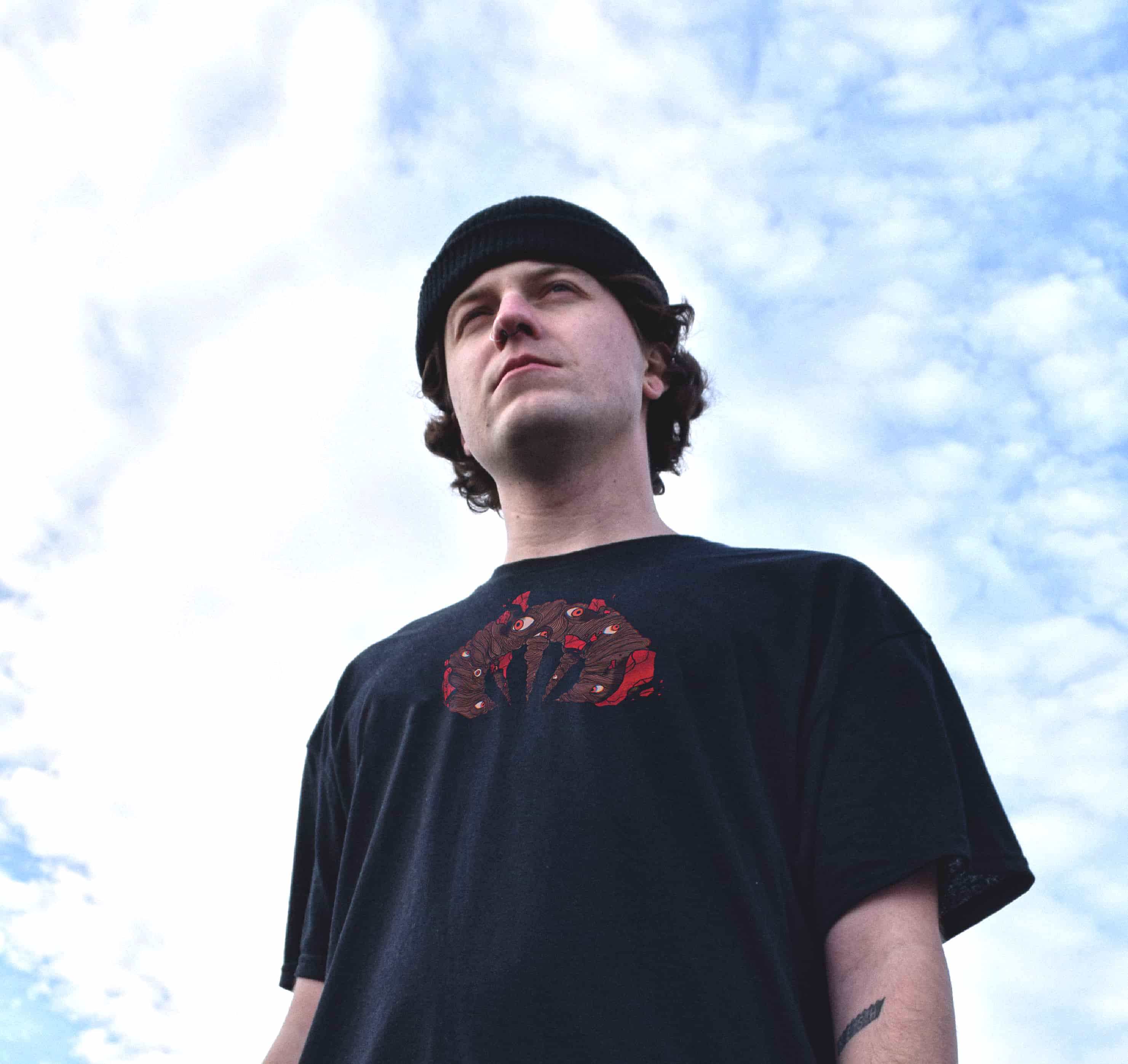 Fashion model in black beanie wearing black streetwear t-shirt .