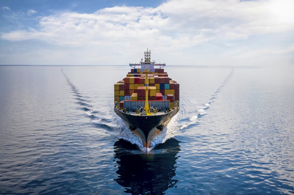 A large container ship filled with colorful shipping containers sailing smoothly on calm waters, symbolizing global trade and maritime logistics.