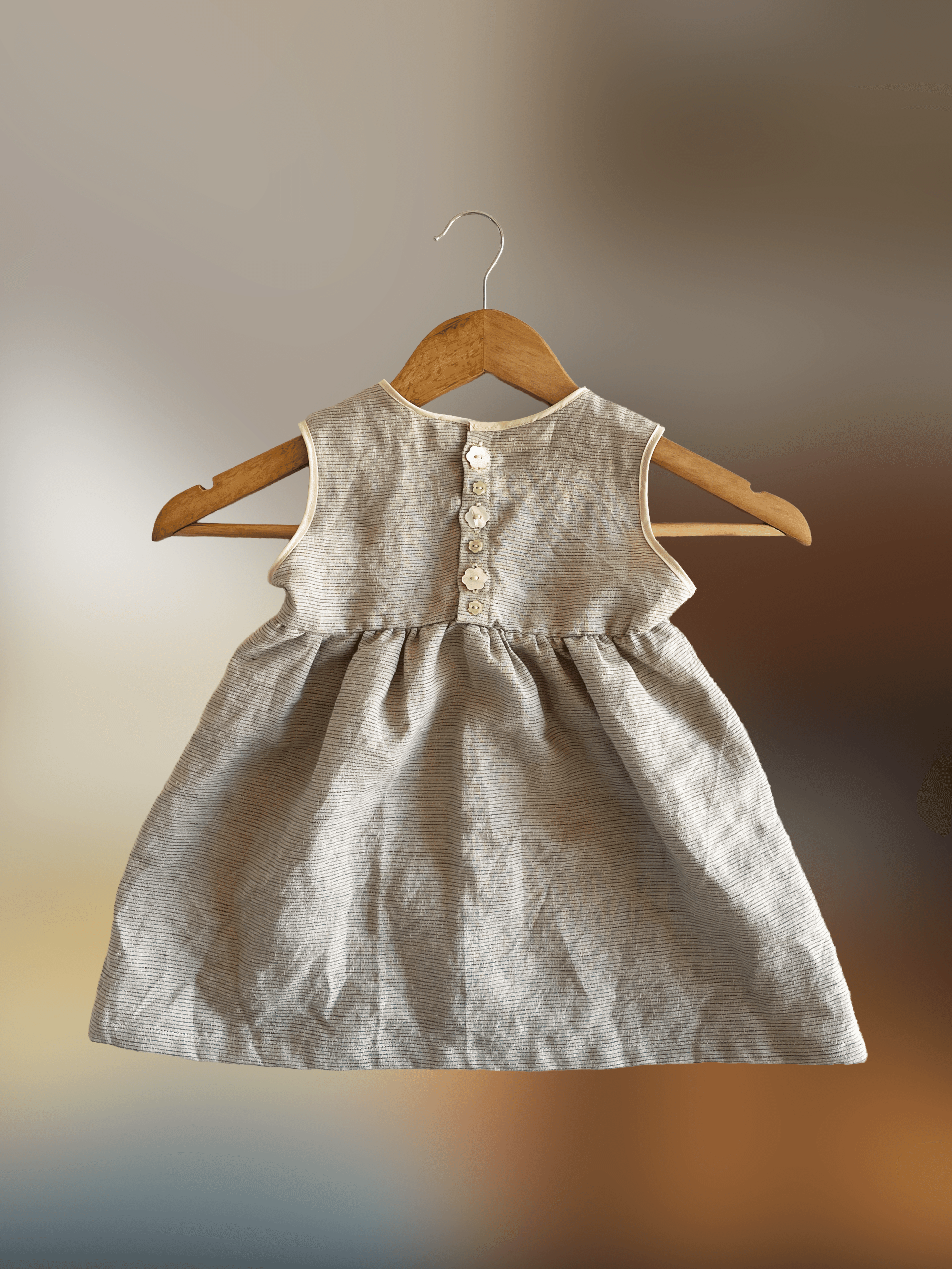 Back of a baby's sleeveless green dress with buttons