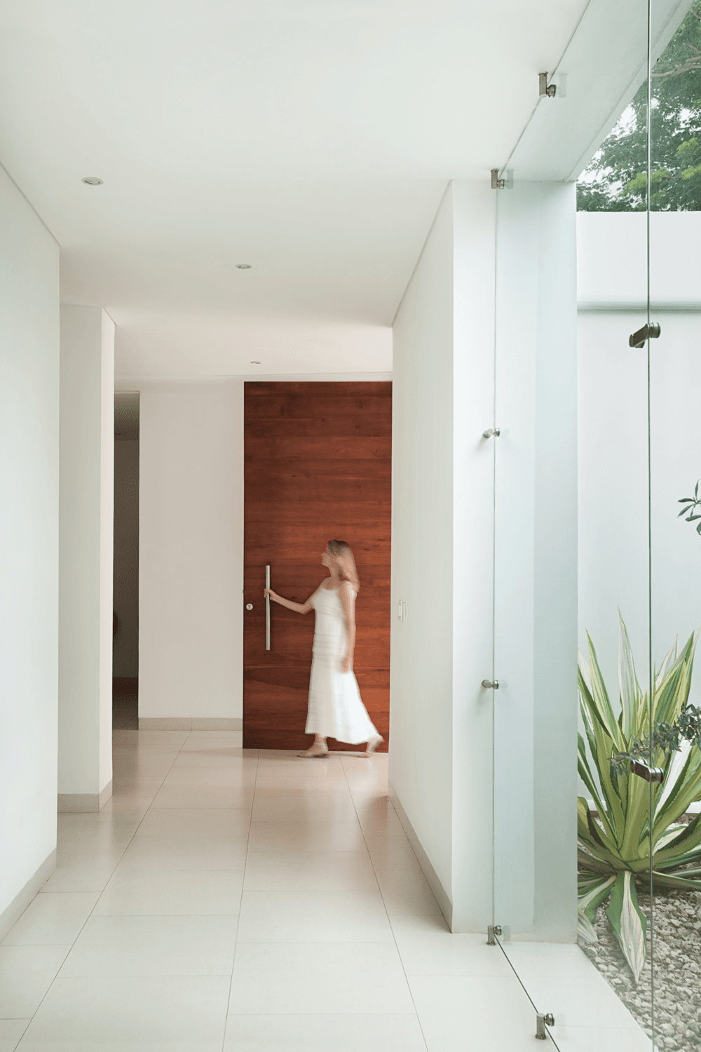 Floor-to-ceiling glazing with courtyard views and timber interior — RA House by Hurtado Arquitectos