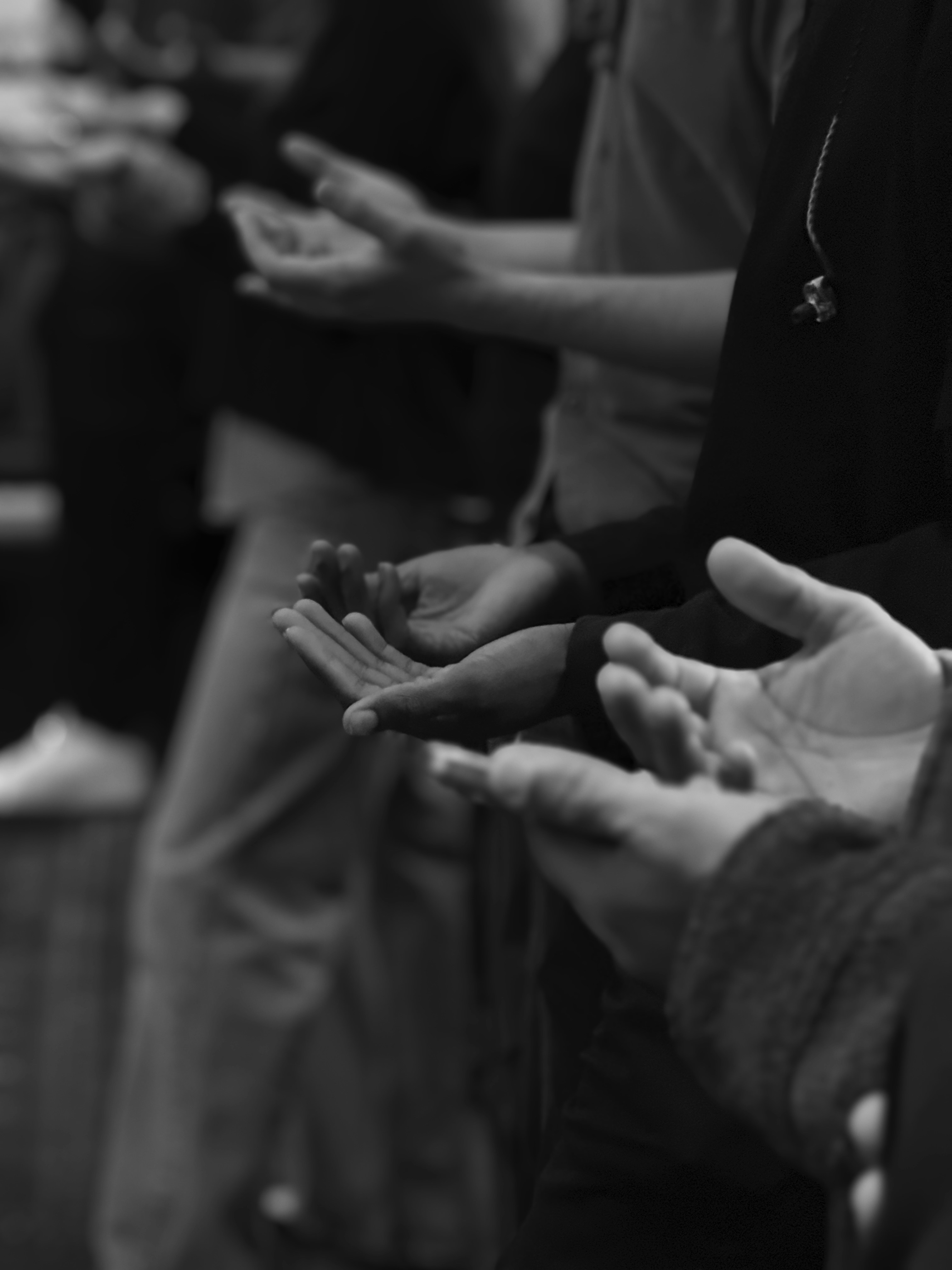 A group of people with open hands in prayer.