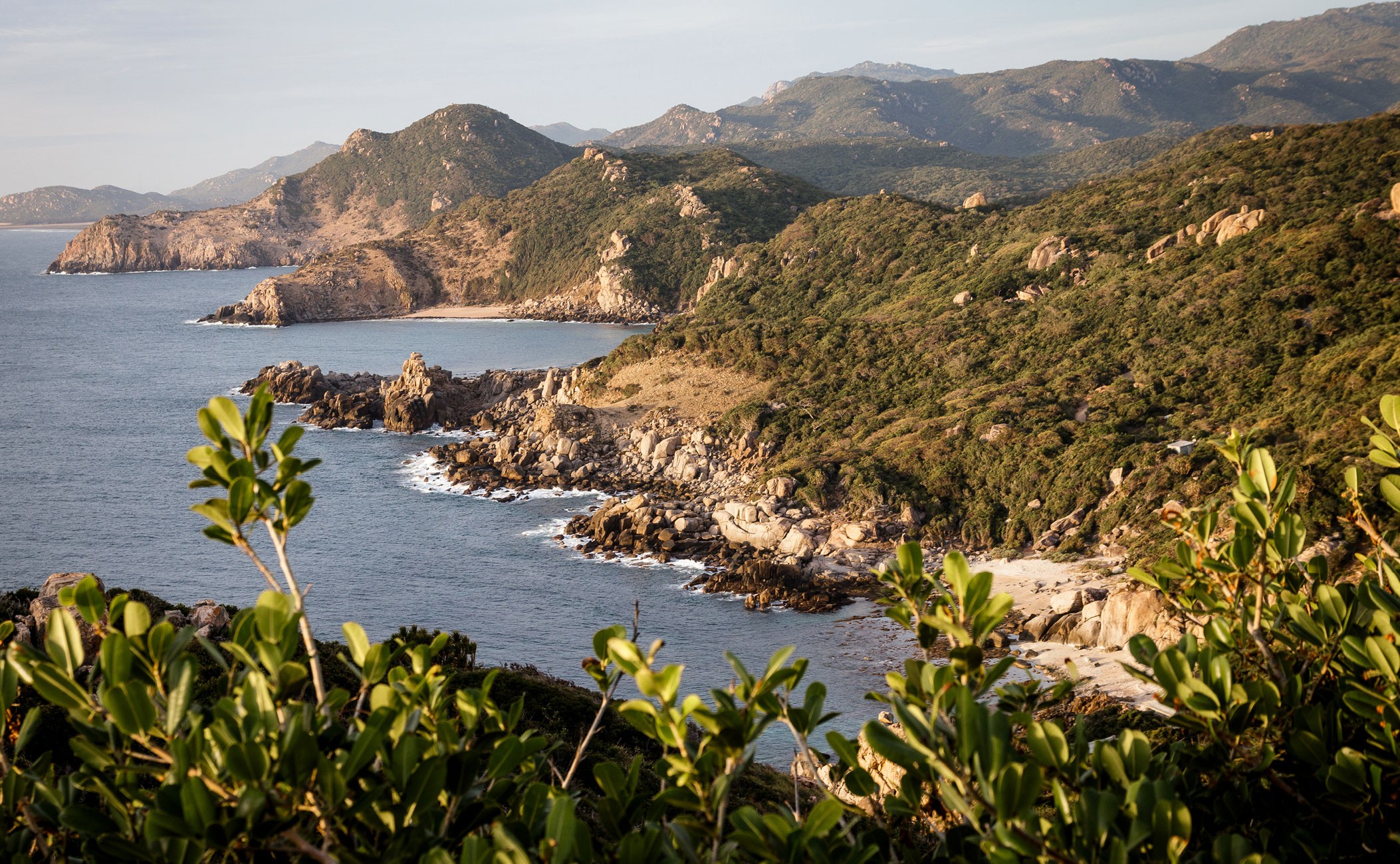Amanoi's forested coastline with rocky outcrops meeting turquoise waters