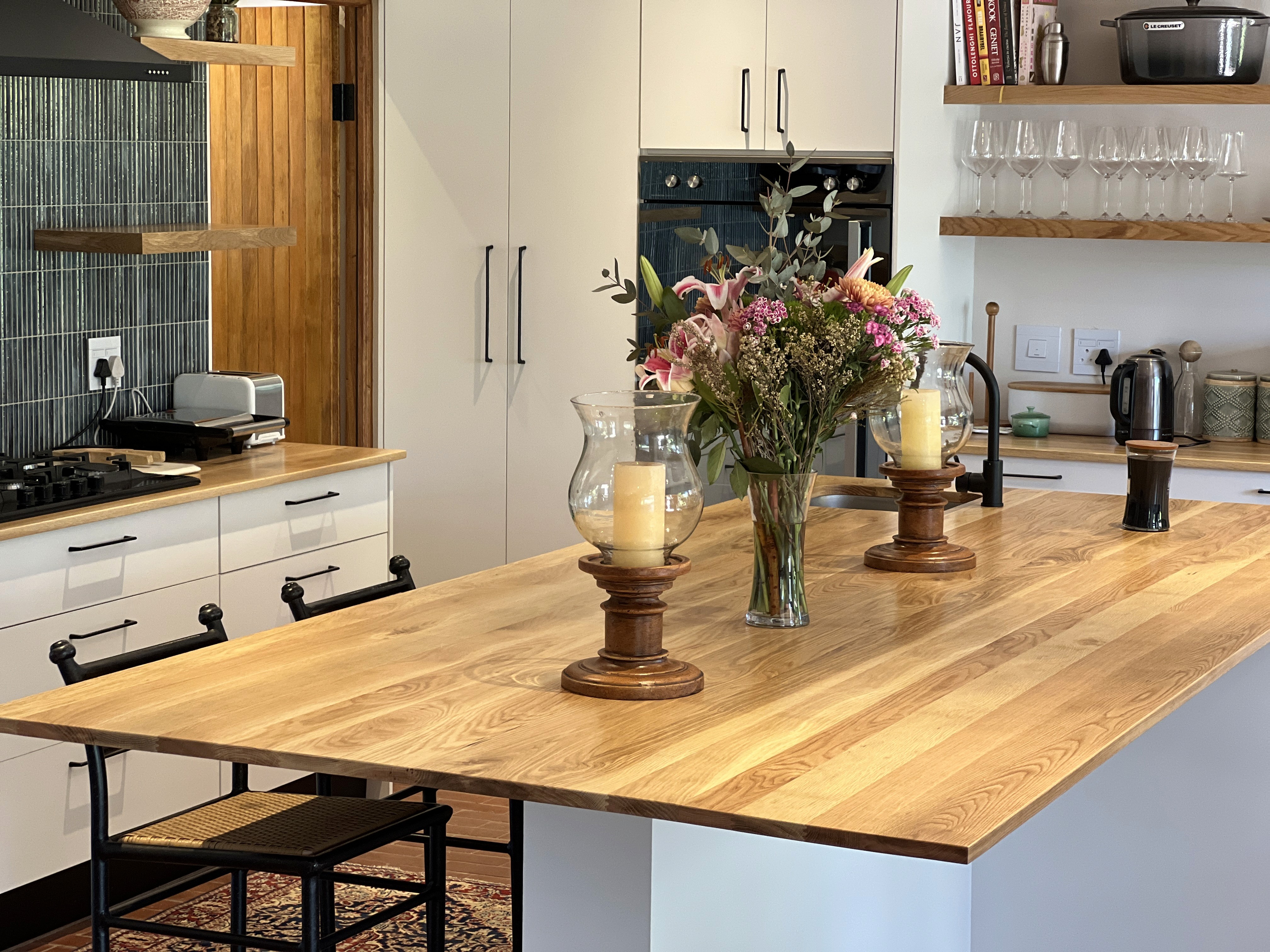Minimalist living space featuring oak flooring, timber wall panels and panoramic windows with natural light.