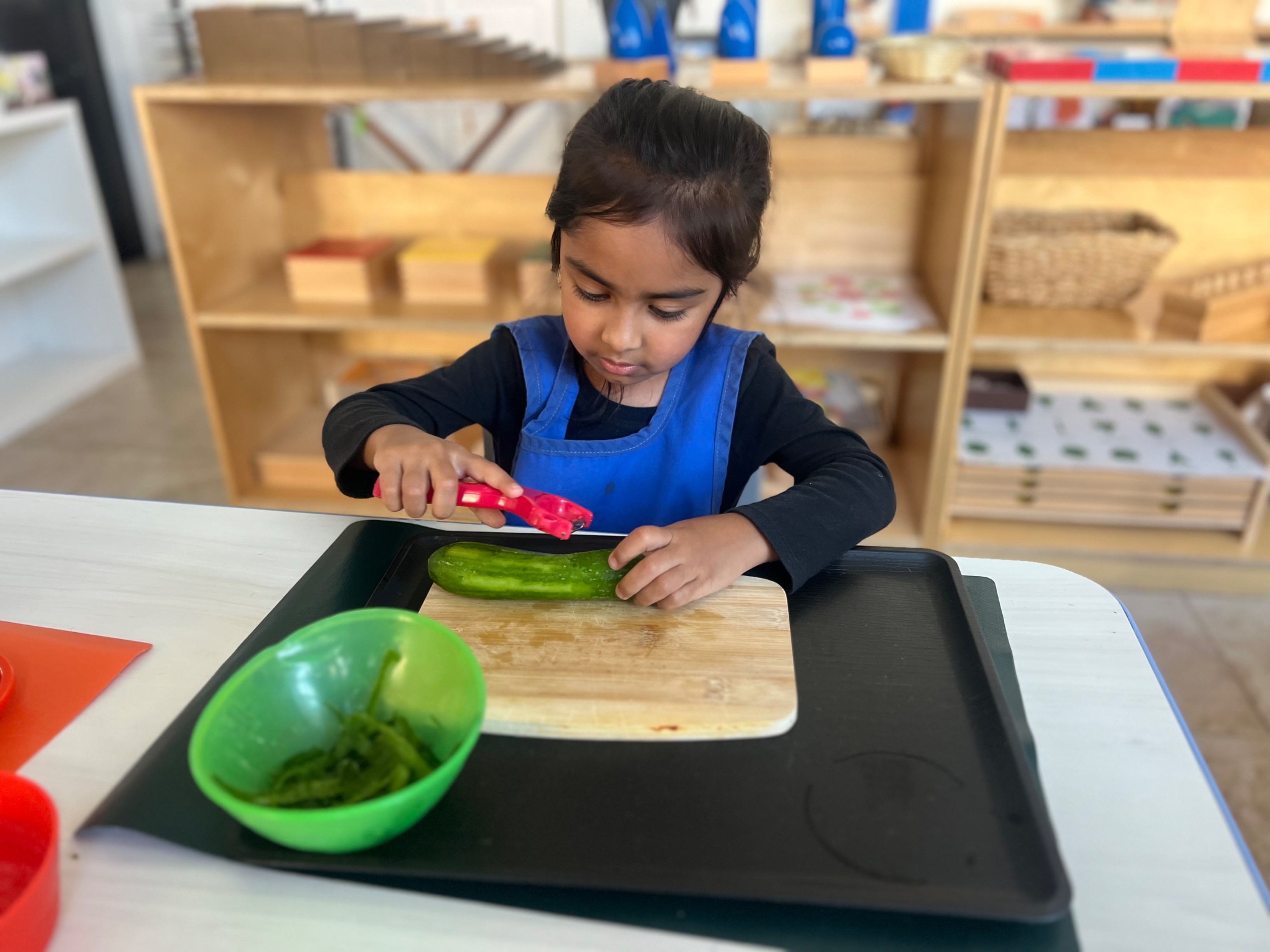 Toddler practicing practical life skills in a Montessori classroom in Irvine, California