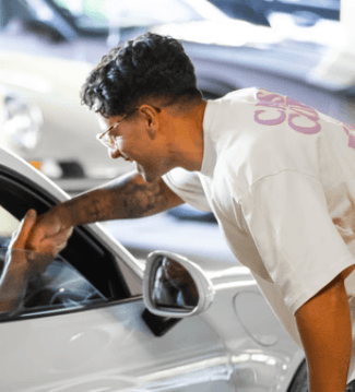 man in black and white striped dress shirt standing near brown leaves during daytime