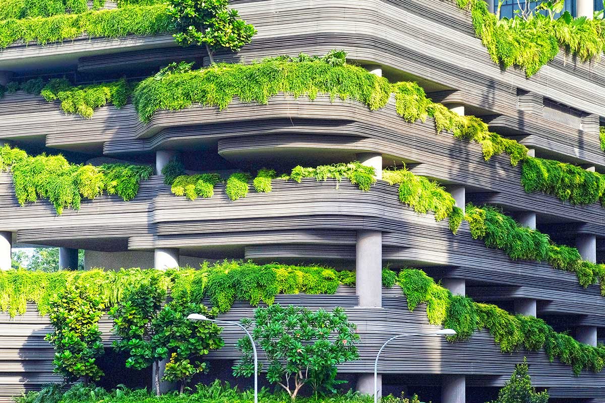 A modern building with plants growing on its balconies.