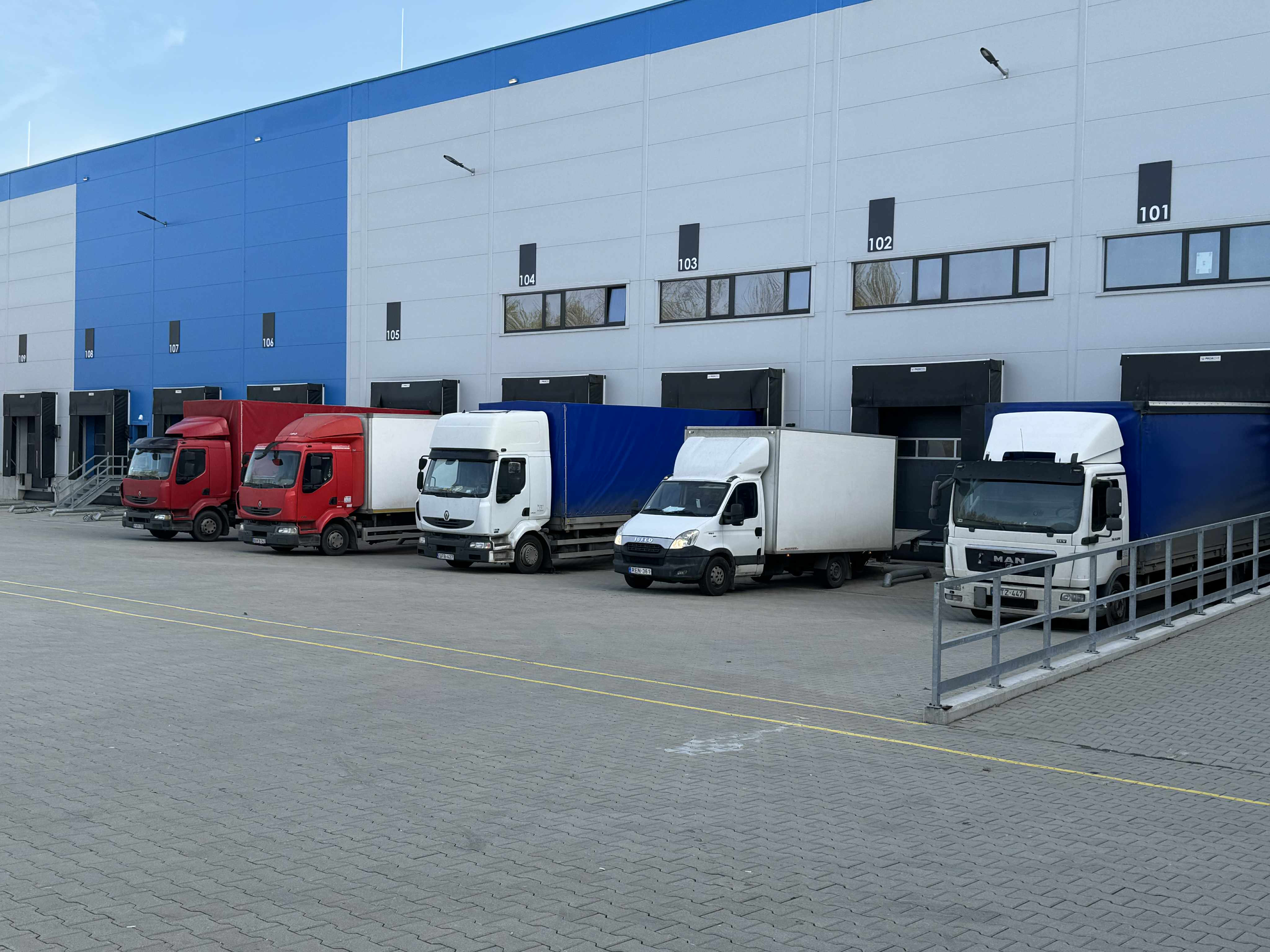 Áruszállítási, fuvarozó kamionok parkolnak egy logisztikai központ rakodójában