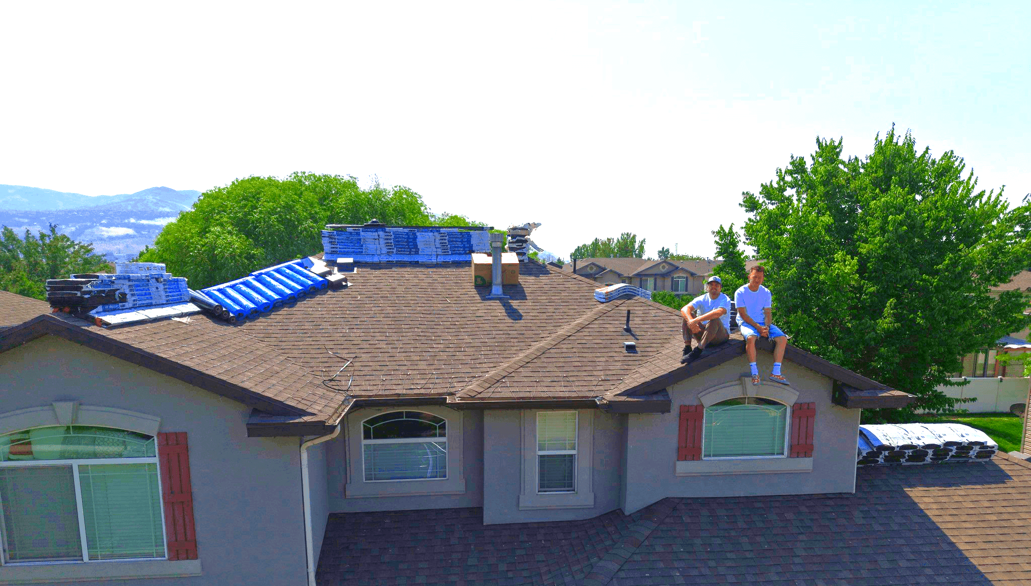 Zion Contracting roofers on top of a completed shingle roof installation in Utah