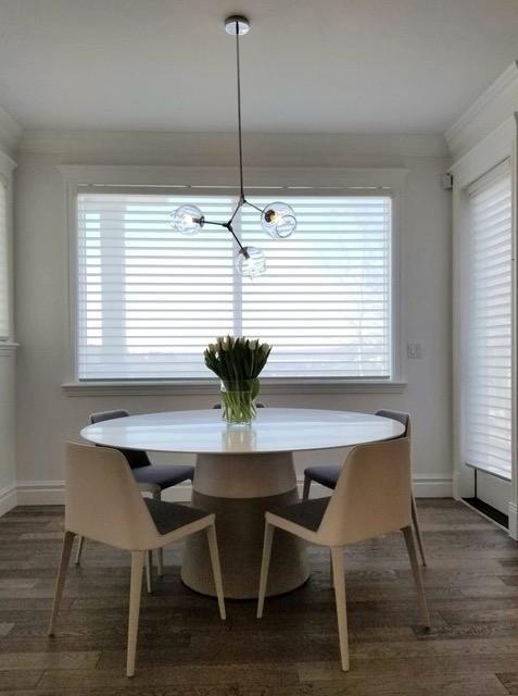 Image of Elegant dining room interior with round table, chairs, and window coverings designed by KHD Homes.