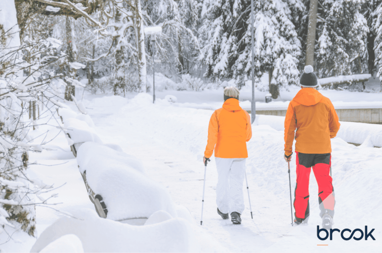 two people in ski boots in snow wearing orange