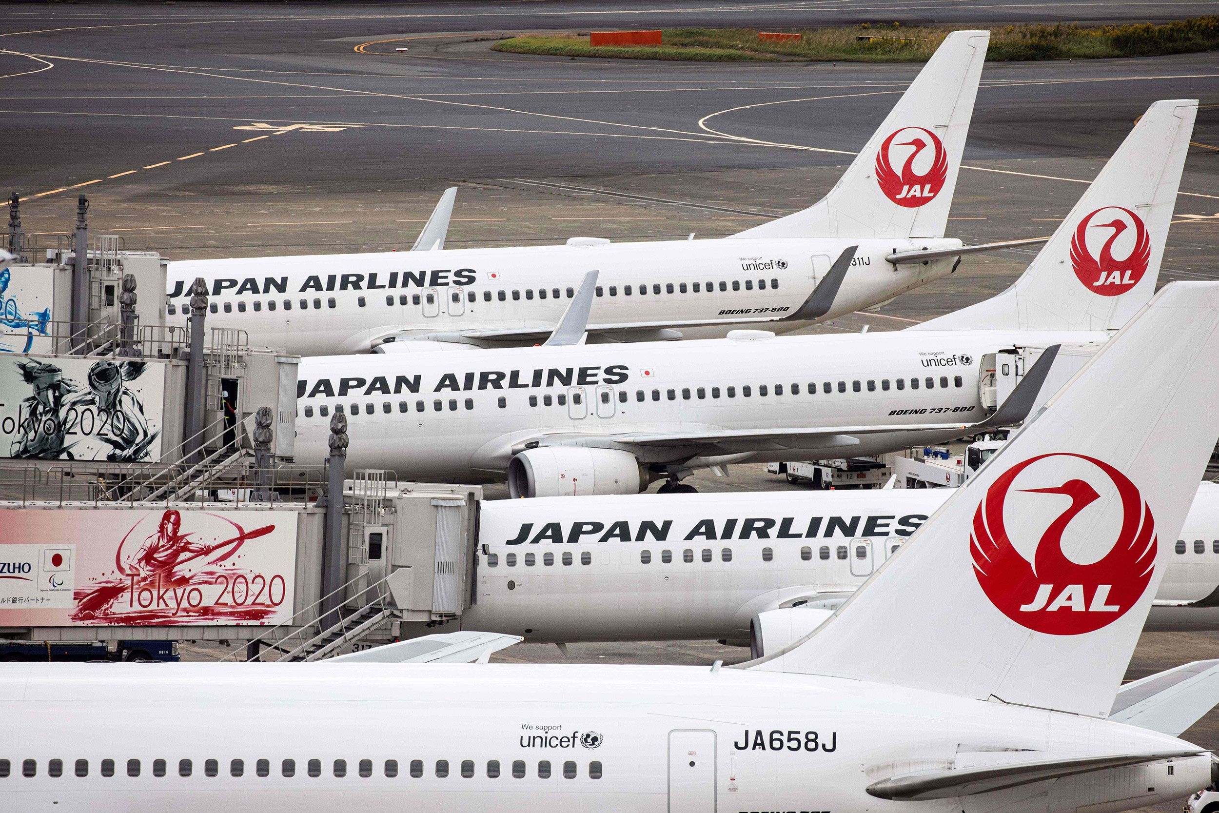 Aviões da Japan Airlines parados em aeroportos enfileirados.