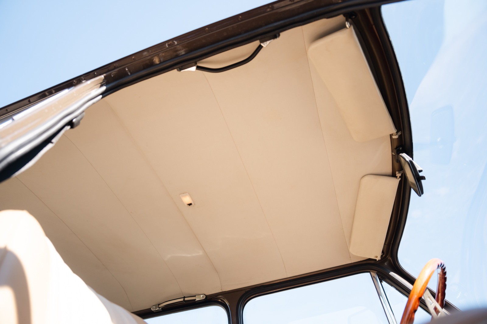 A close-up view of a beige tent or awning with a blue sky background.