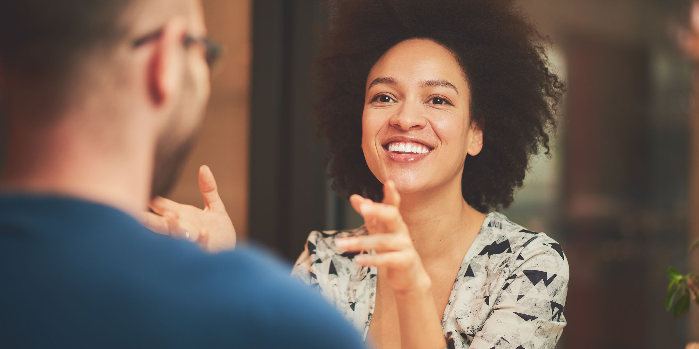 Smiling woman talks with a colleague at the APAP office