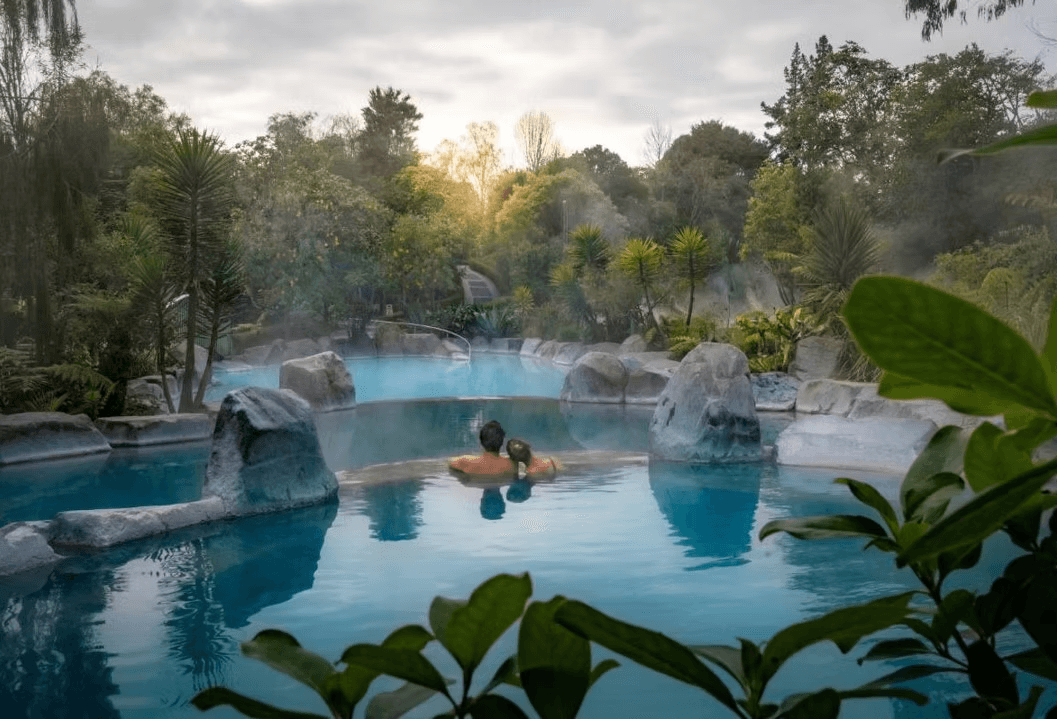 A picture of the Wairakei Terraces Hot Pools with a couple soaking in one of the pools. 
