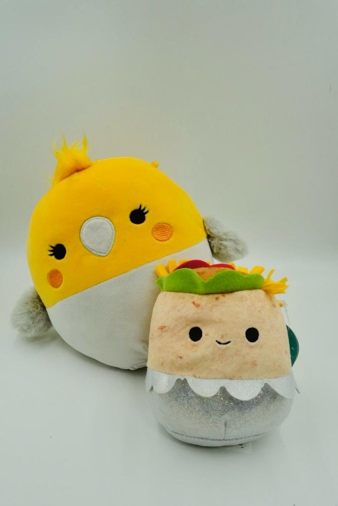 A stuffed animal toy with a yellow bird and a white background
Description automatically generated