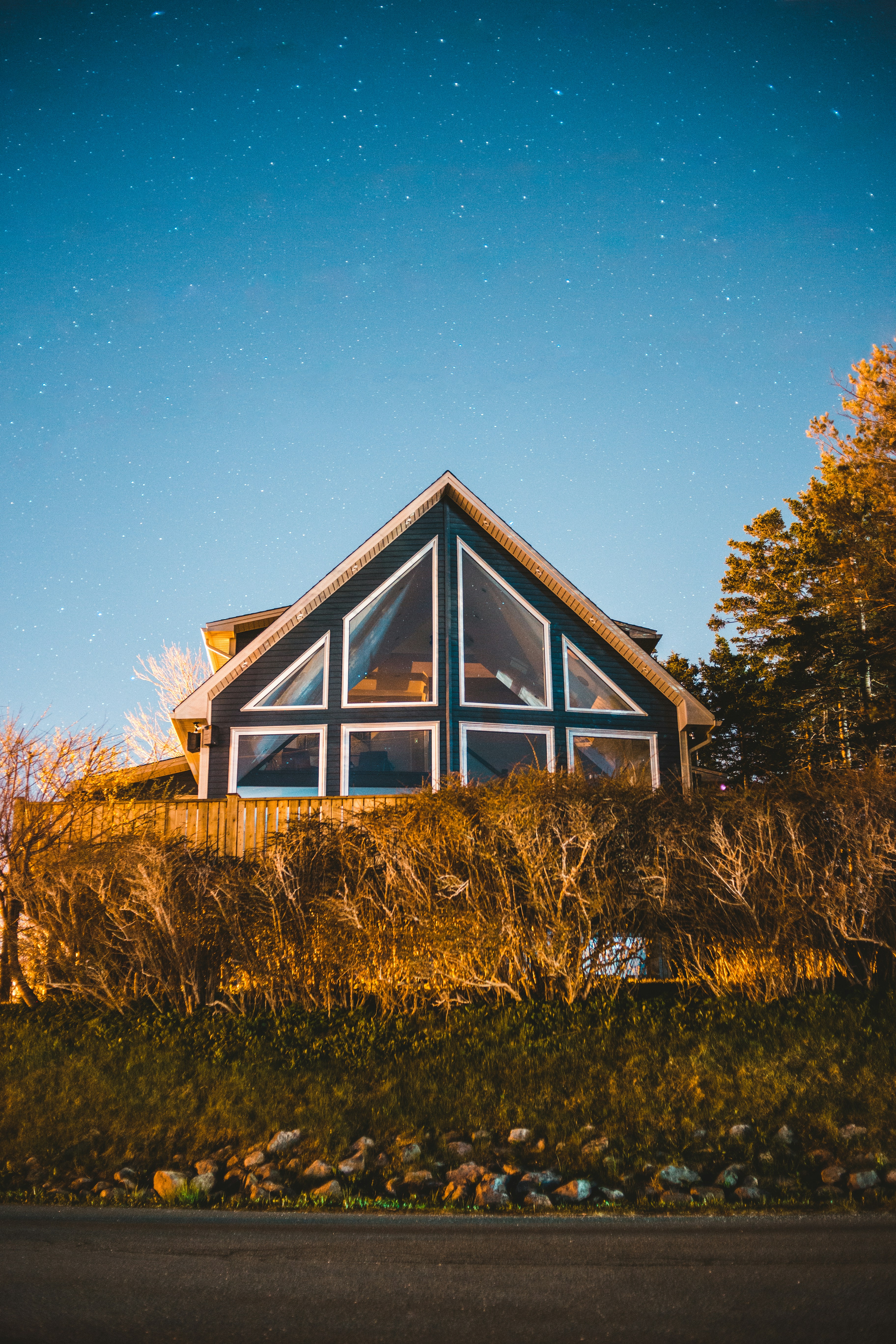 brown and white wooden house surrounded by green grass field during daytime