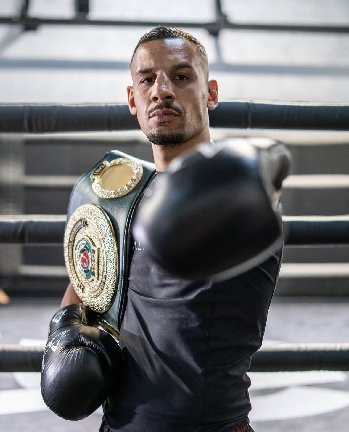 Photo of Evo X founder Deri Morgan seated outdoors at sunset with ocean view in the background