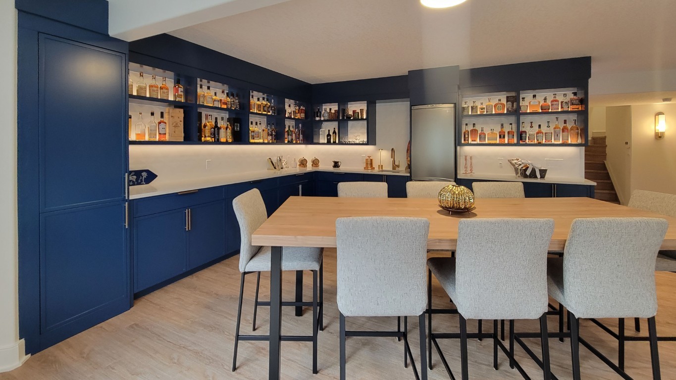 Image of KHD Homes design-build kitchen with bar, dining table, and blue cabinets showcasing interior design expertise.